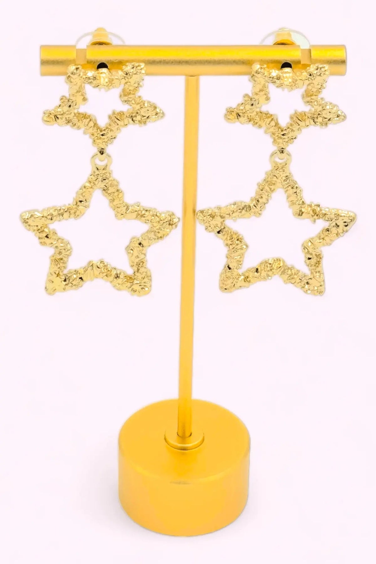 Stella gold-plated star drop earrings with open, hammered-texture stars in a tiered drop