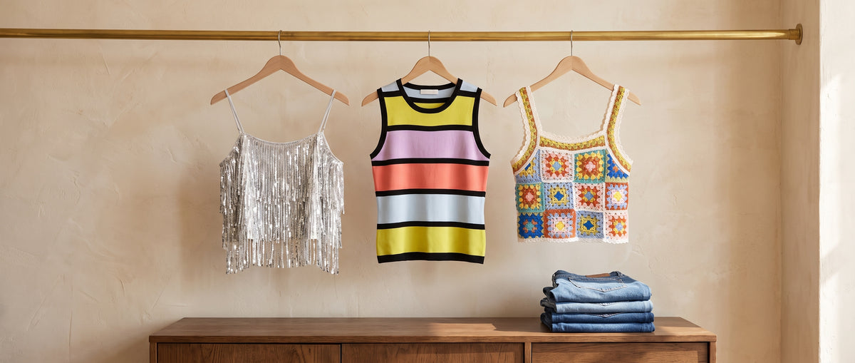 A silver sequin fringe cami, a colour-striped knit tank and a crochet granny-square tank on a brass rail