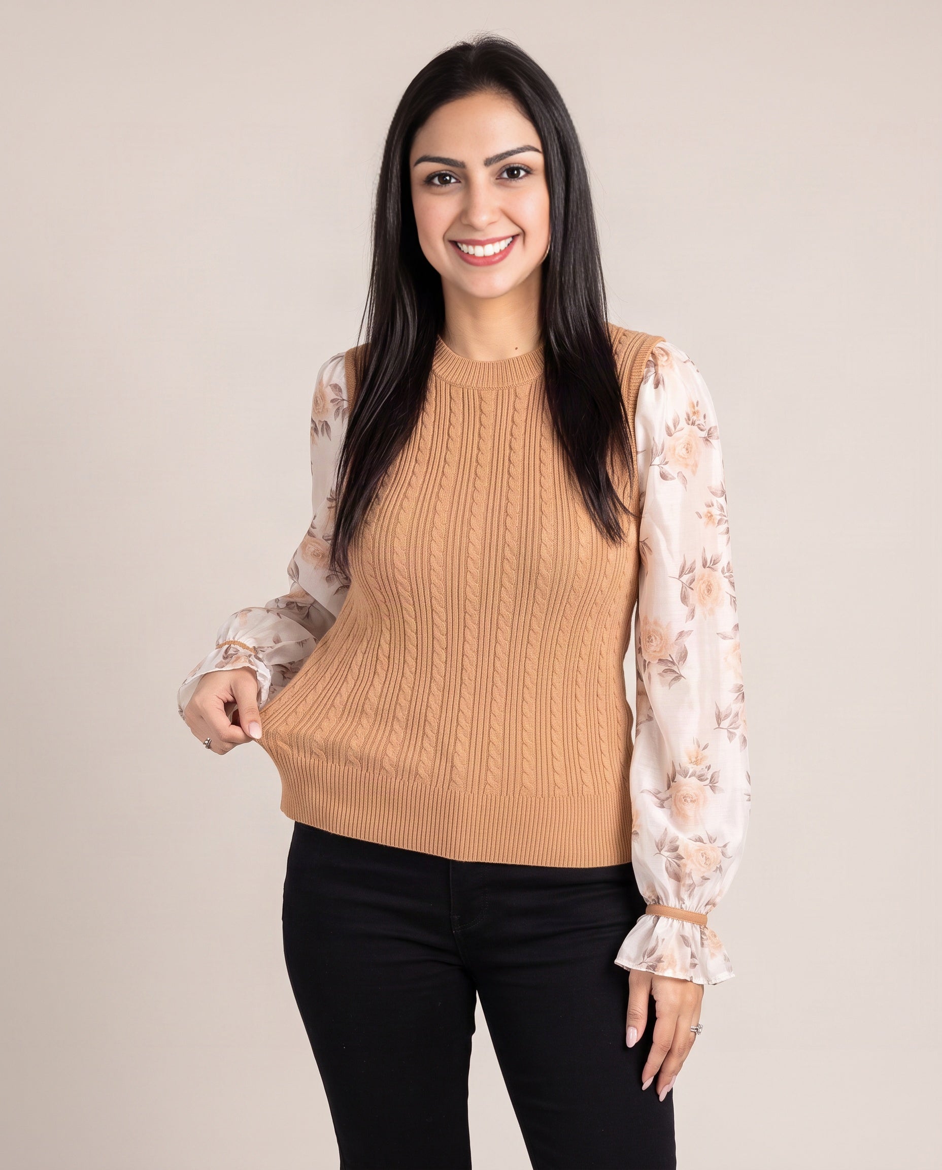 Shweta gently drawing out the Tan sweater hem to show the knit body's flexible fit.