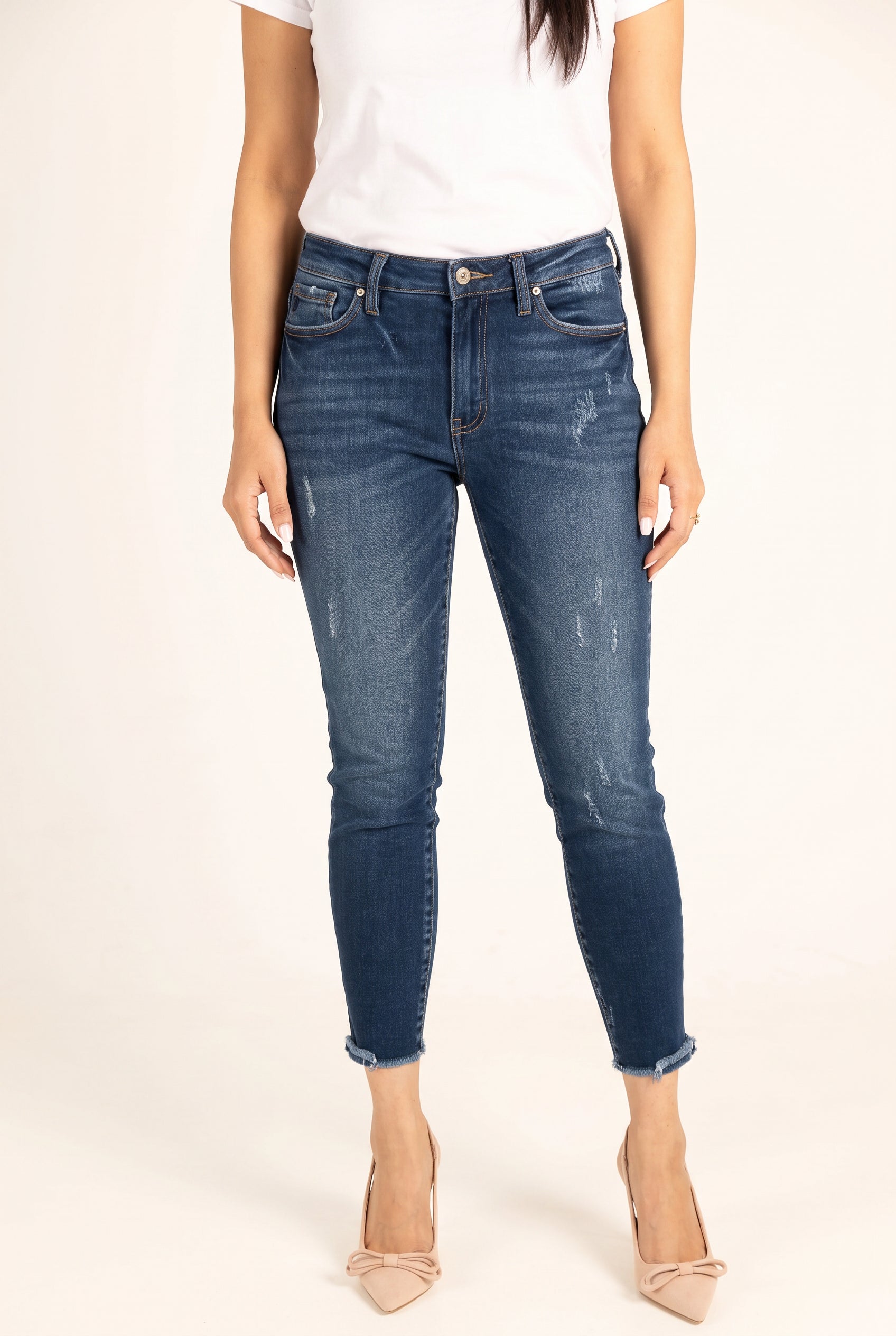 Close view of Beautiful Day Mid Rise Ankle Jeans showing the blue wash, light abrasions and frayed hems.