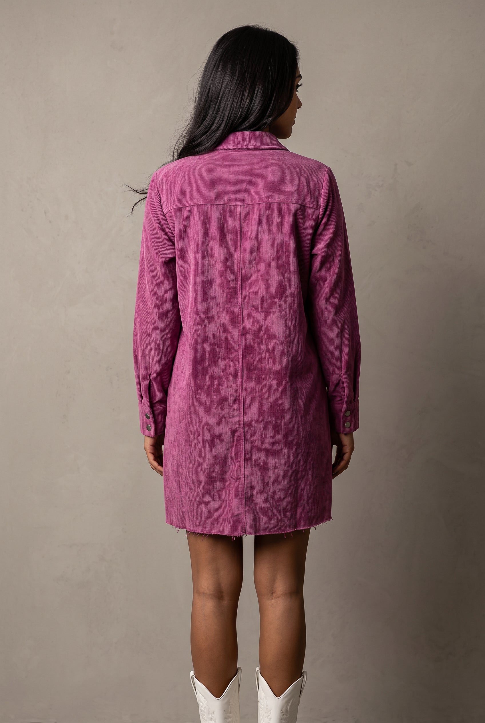 Back view of the Part Of My Story corduroy shirt dress showing its yoke, center seam and raw hem.