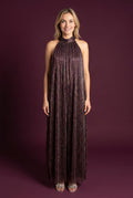 Elsa wearing the All That She Wants Jumpsuit, showing its halter neck and full wide-leg silhouette.