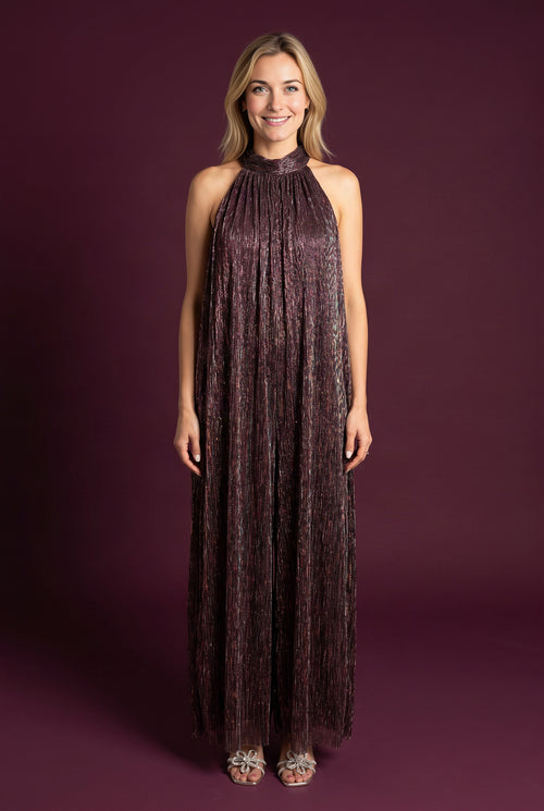 Elsa wearing the All That She Wants Jumpsuit, showing its halter neck and full wide-leg silhouette.