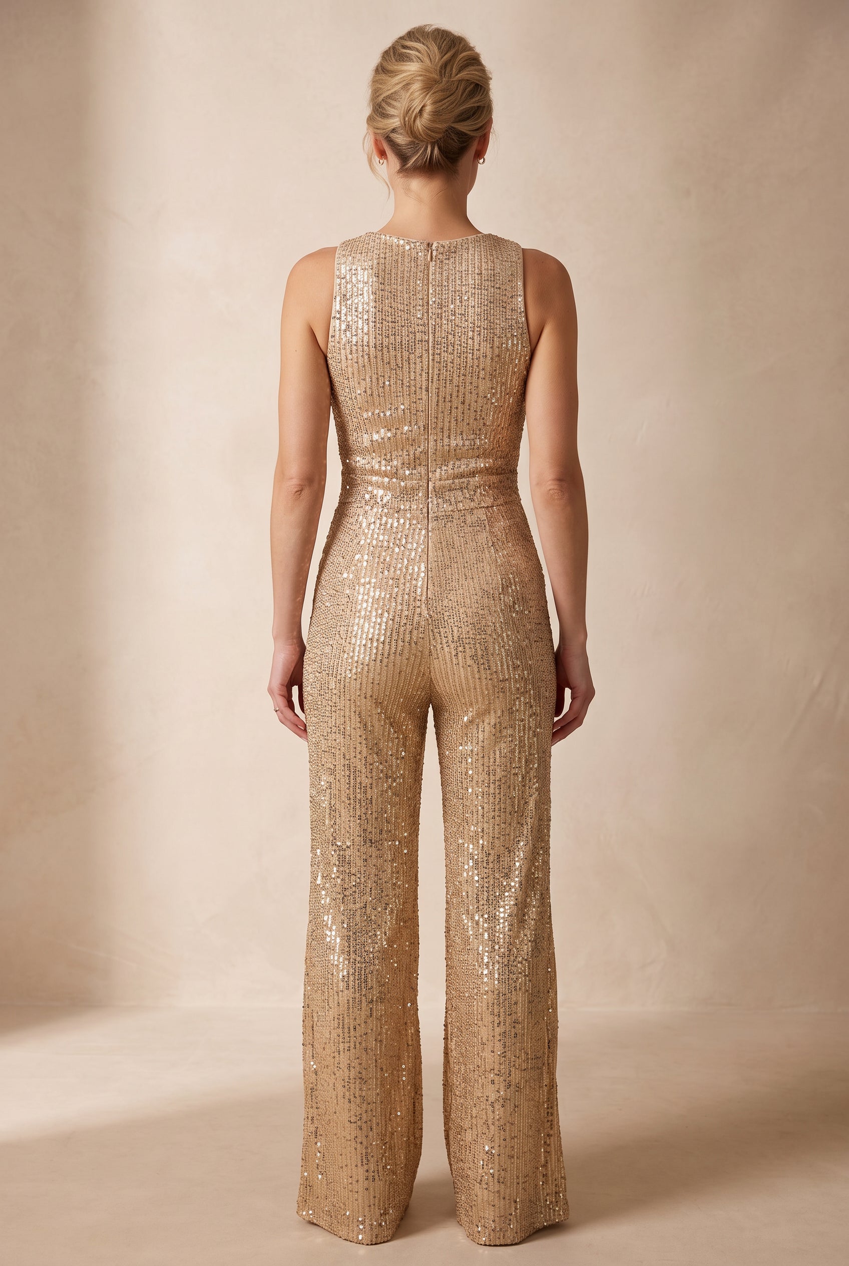 Rear view of the gold sequin jumpsuit showing the high back, seat fit and wide-leg fall.