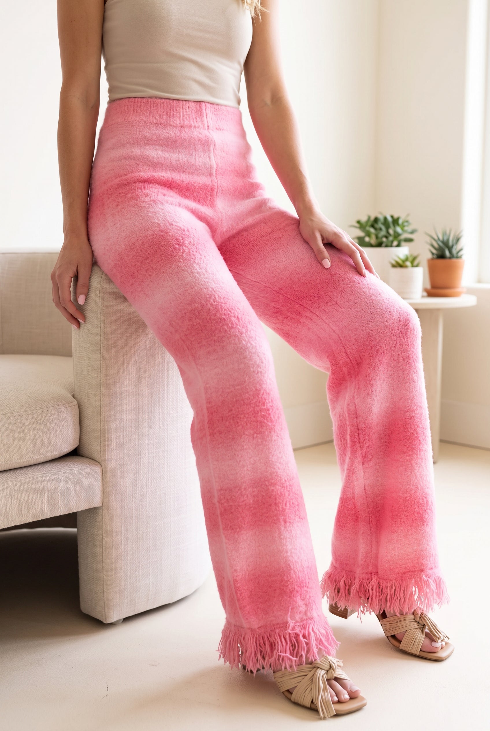 Softly Spoken pink ombré pants worn by Elsa in a bright lounge setting with the waist and fringe visible.