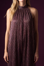 Close view of the jumpsuit's plum-bronze pleats and multicolour metallic shimmer.