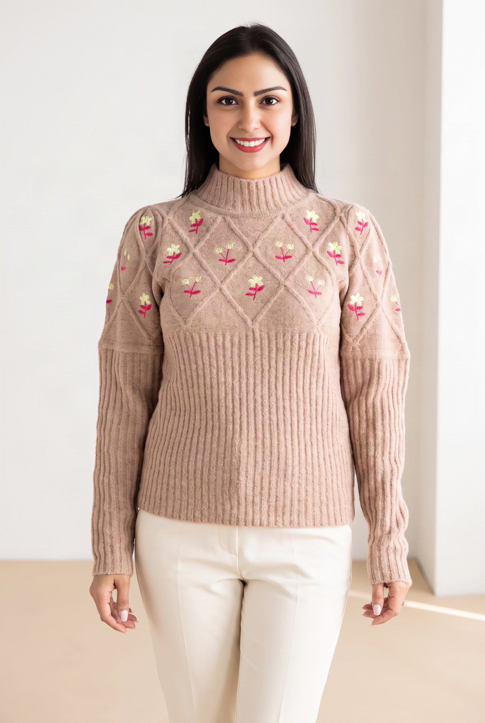 Happy Times Floral Sweater showing its mock neck, floral yoke, and hip-length fit with ivory trousers.