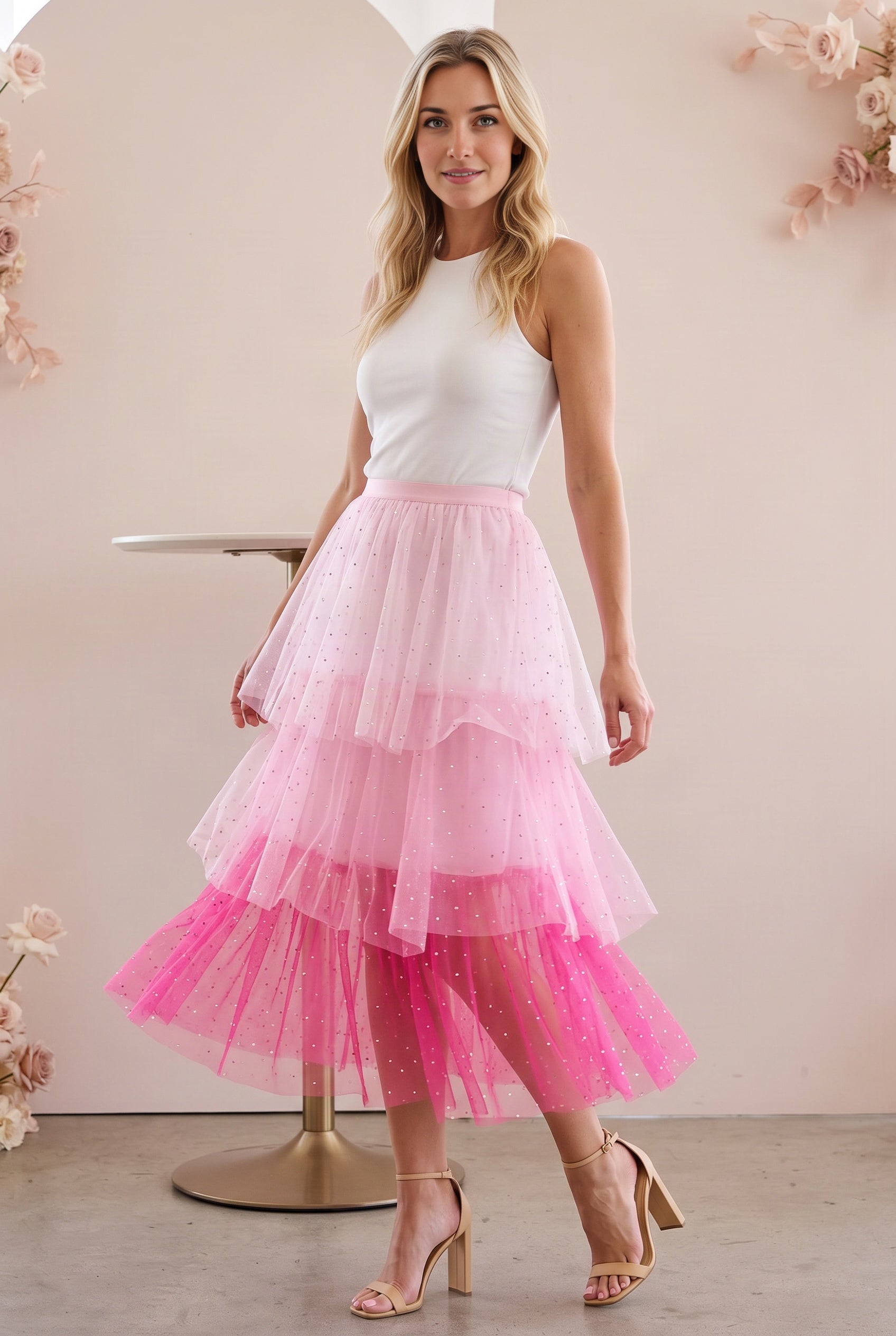 Elsa styles the pink tiered tulle midi skirt for an indoor celebration with a fitted ivory top.