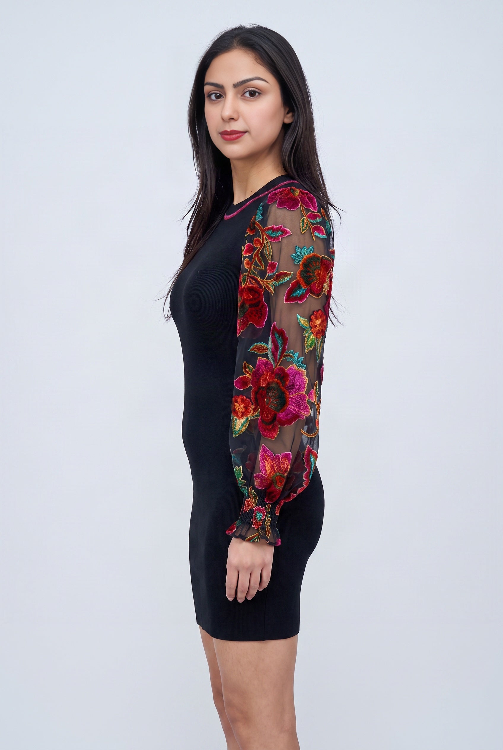 Side fit of the black sweater mini dress showing its body-skimming shape and balloon sleeve volume.