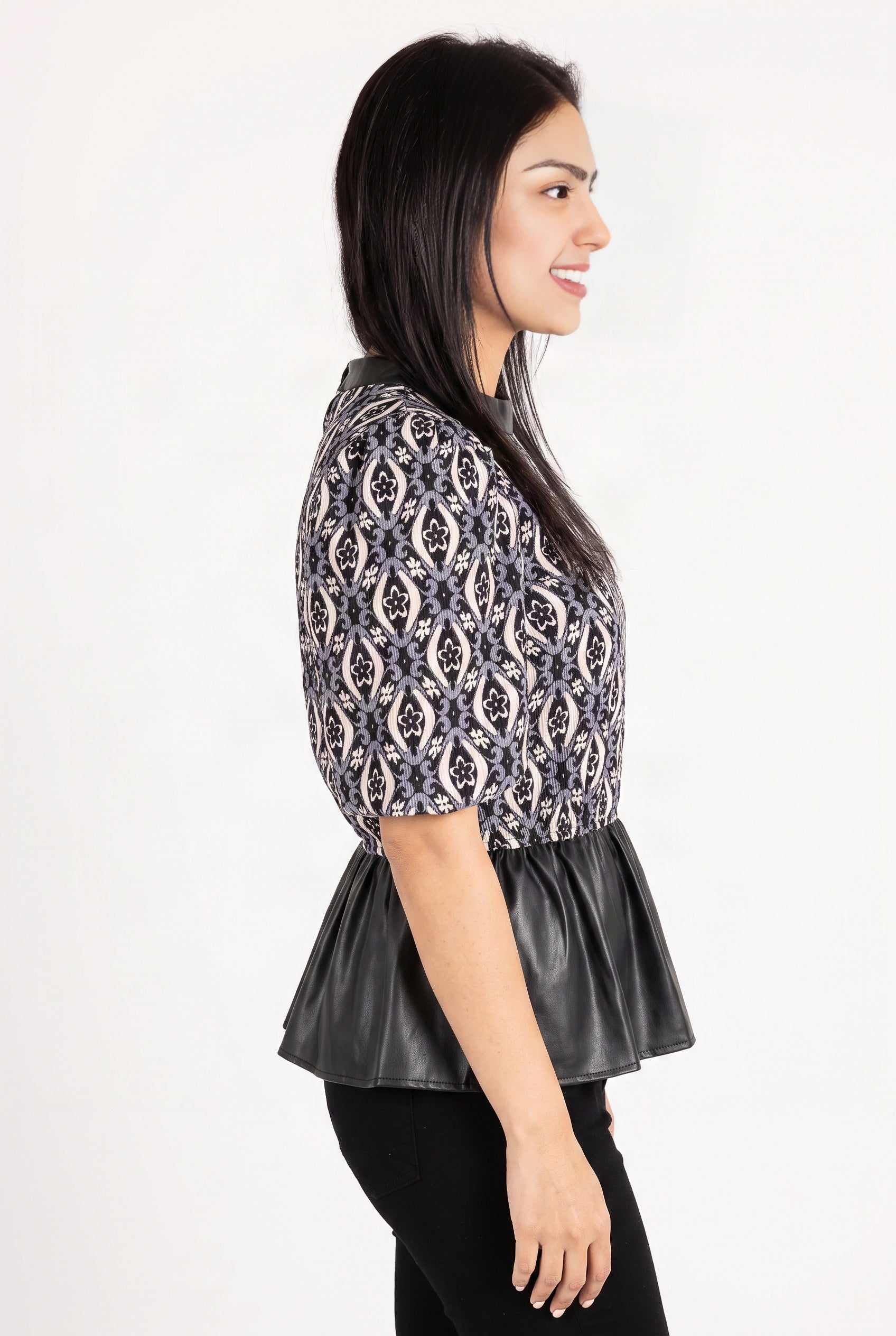 Side fit of the Last Night peplum top showing sleeve volume and the faux-leather peplum over the hip.