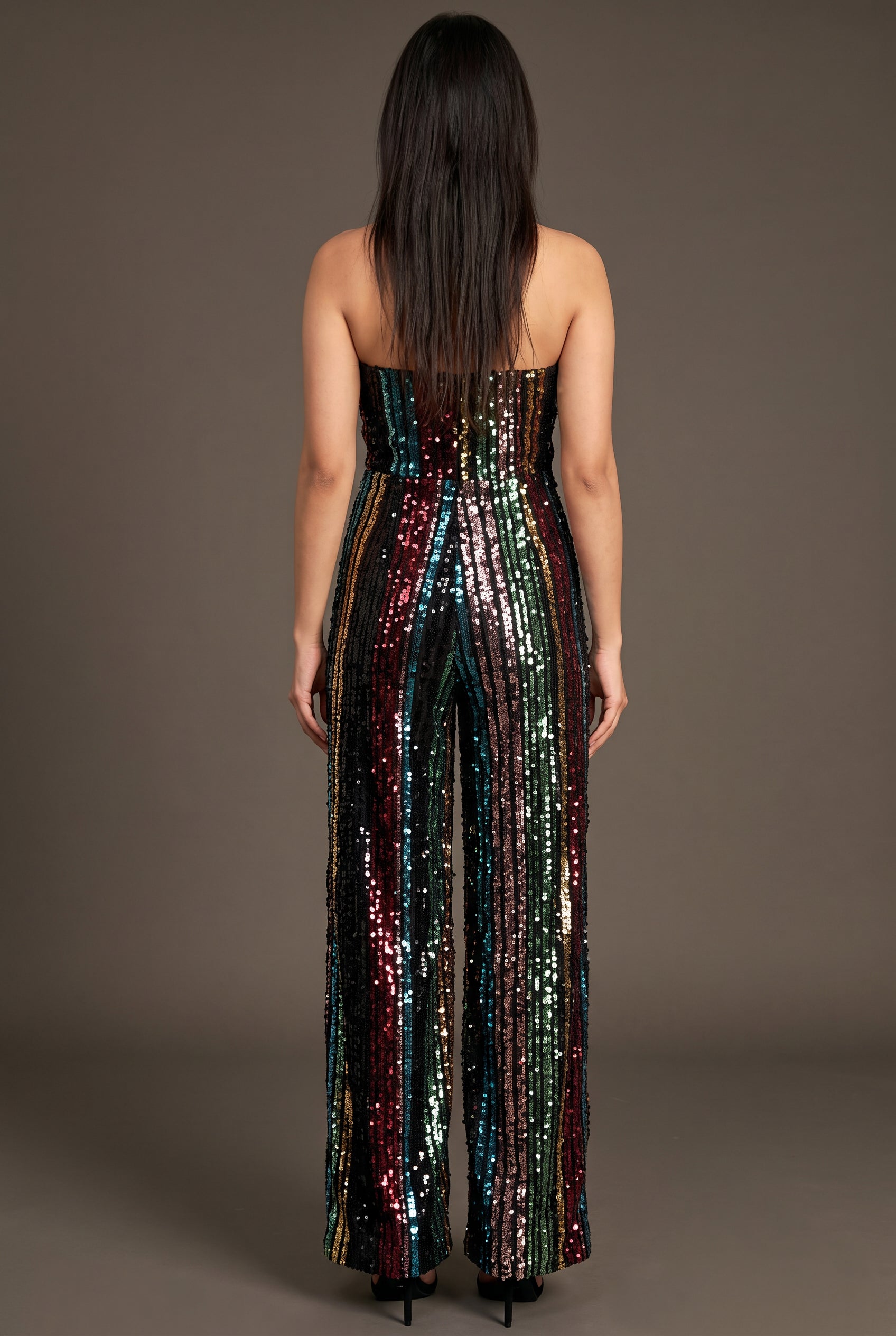 Back fit of the jumpsuit showing its straight strapless back and continuous sequin stripes.