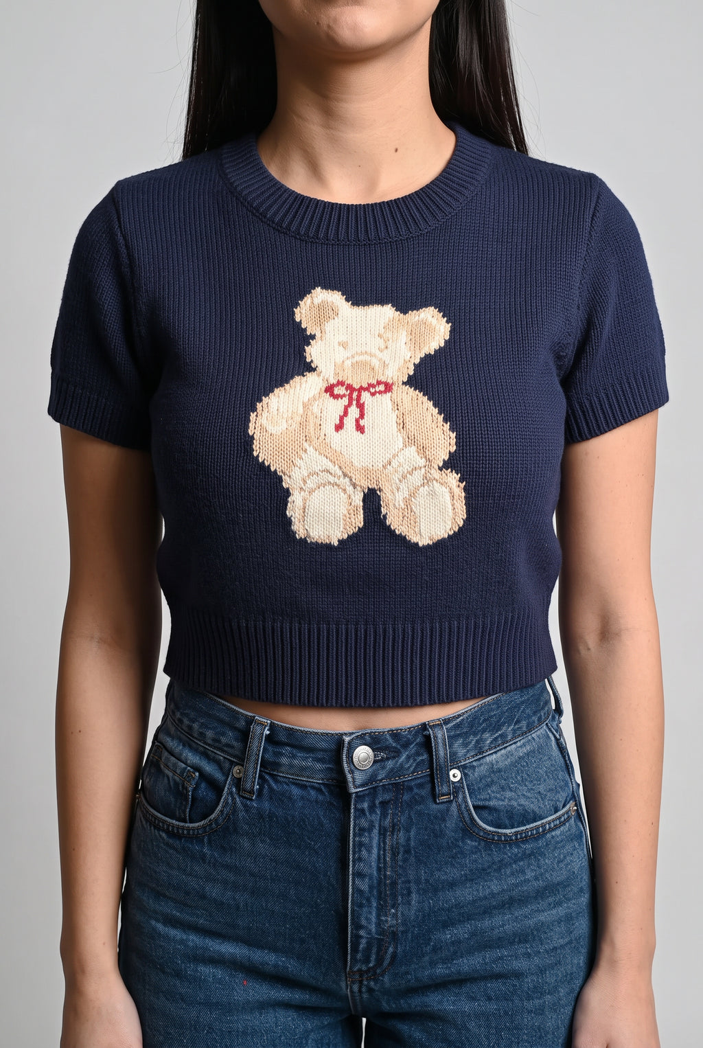 Close view of the navy teddy bear sweater top showing the bear motif and ribbed knit.