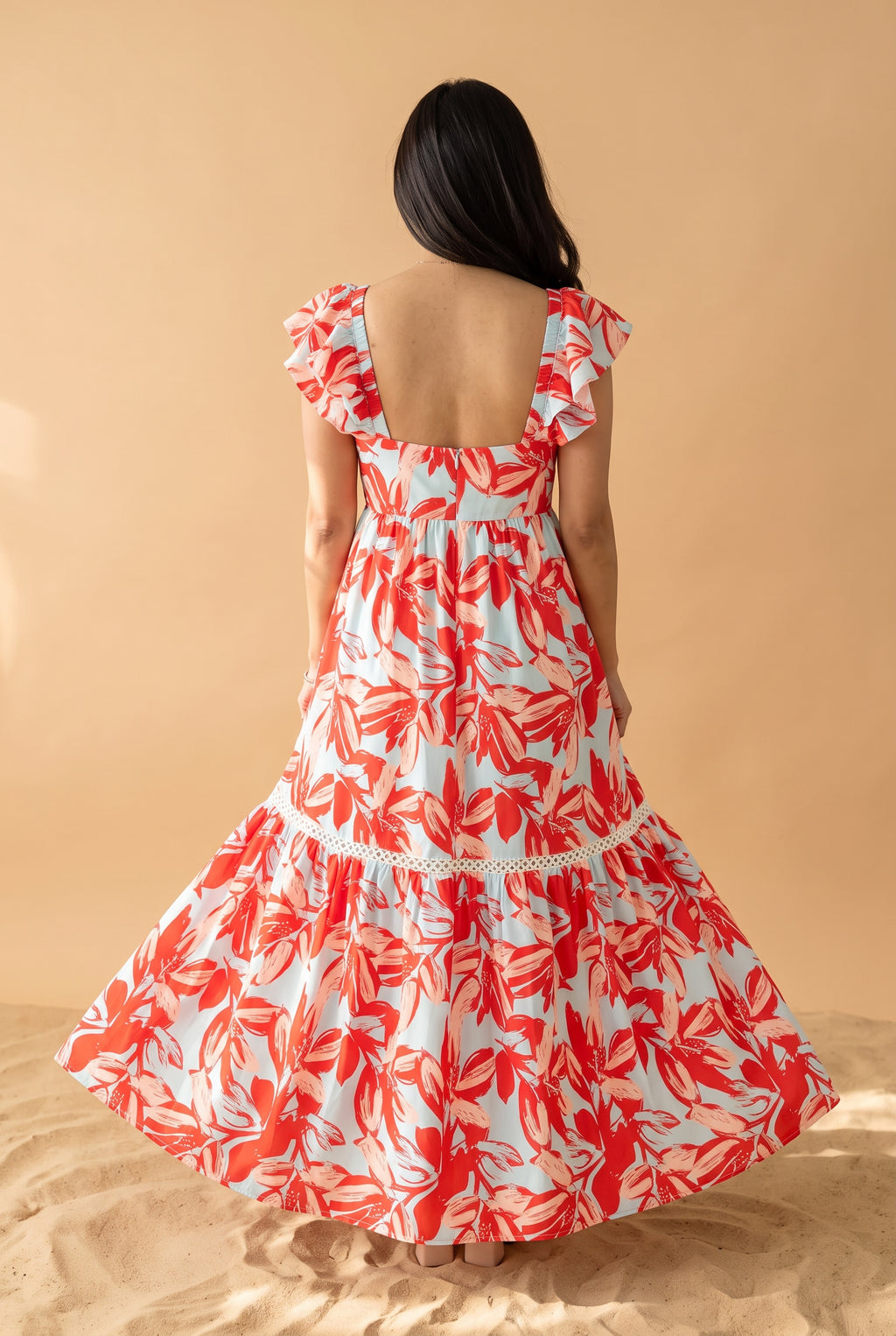 Back view of the Painted The Sky Floral Maxi Dress showing its low square neckline and full tiered skirt.