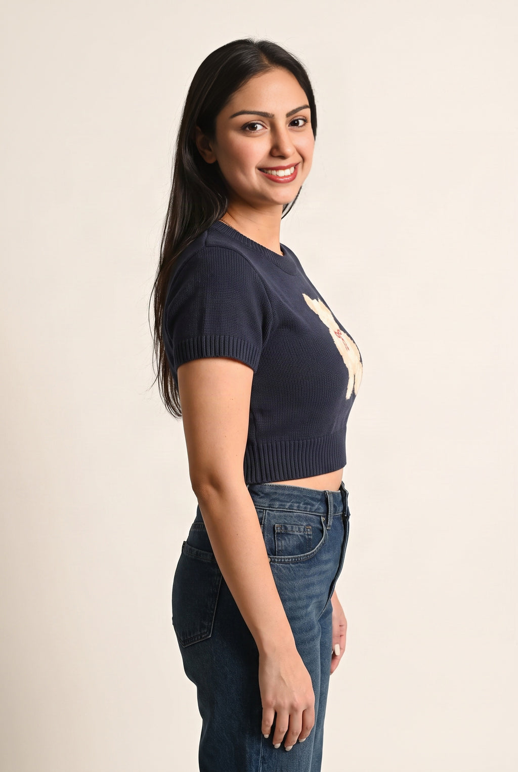 Side fit of the navy teddy bear sweater top showing its crop length and sleeve profile.