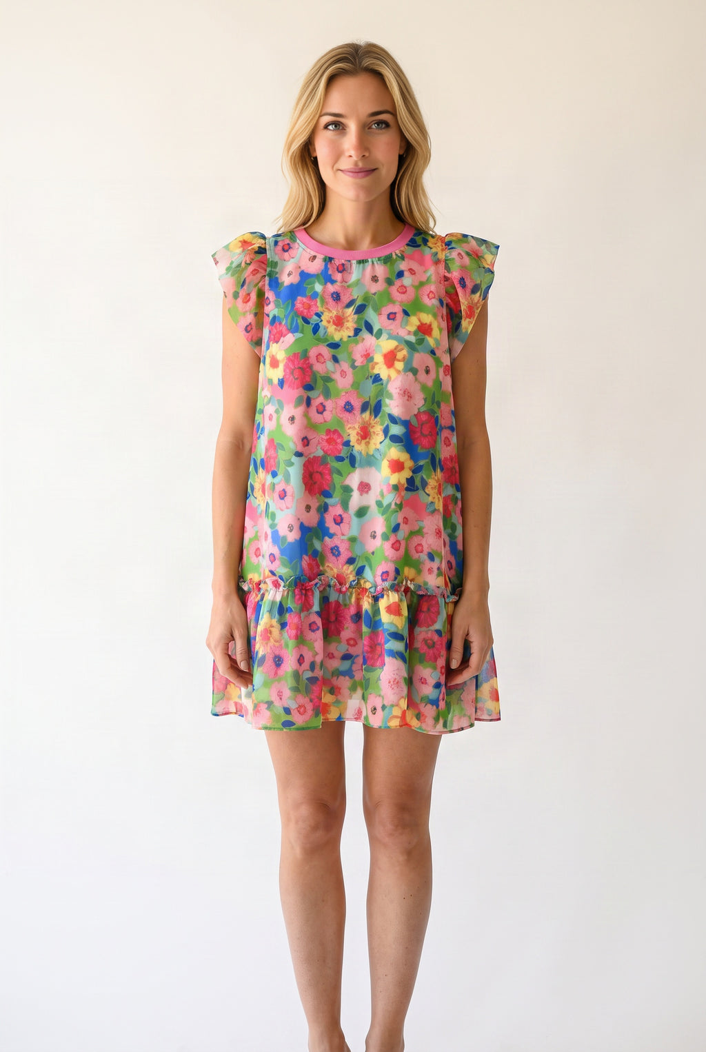 Elsa wearing the Keep Blooming floral mini dress, showing its loose A-line fit and above-knee length.