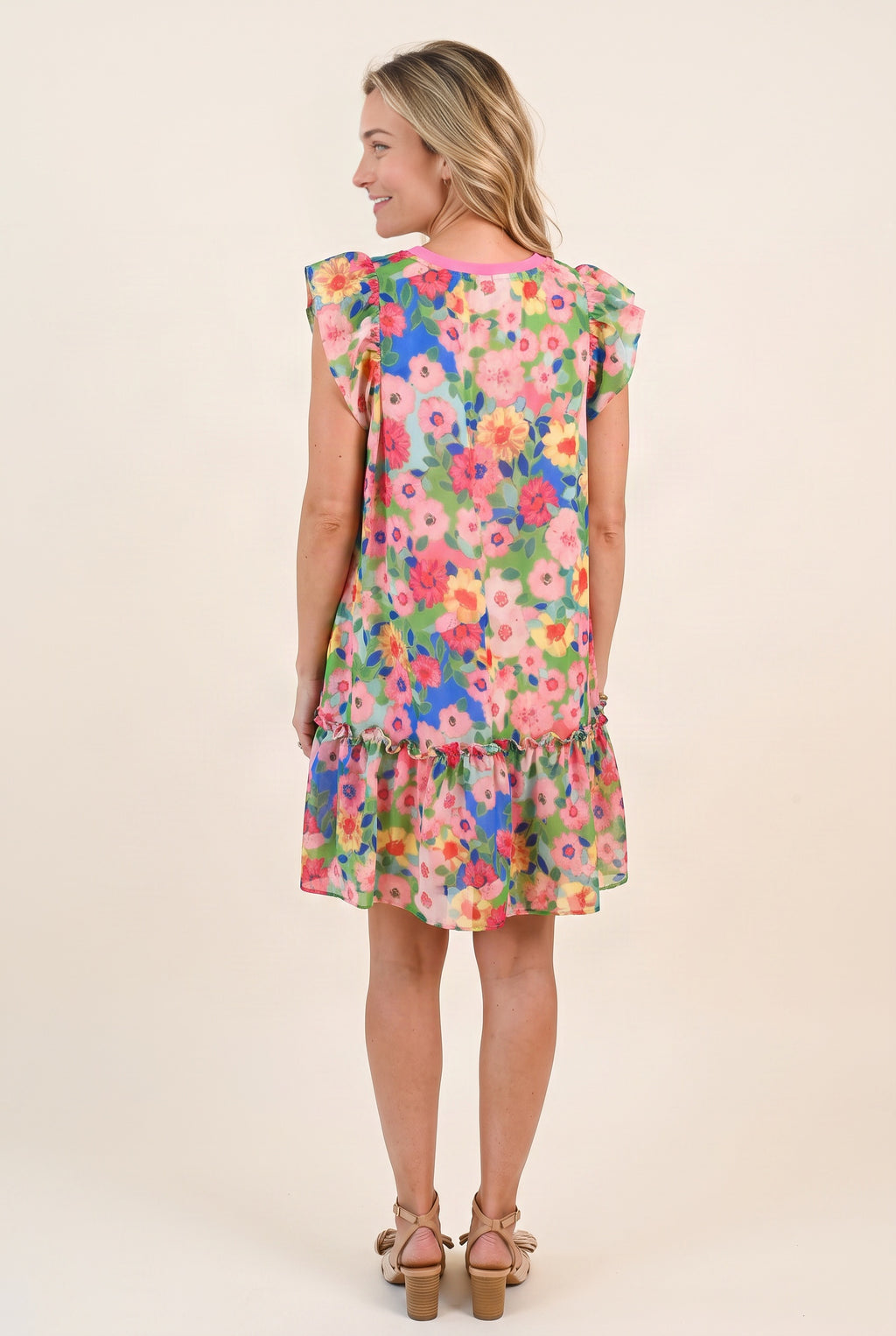 Back view of the Keep Blooming floral mini dress showing the neckline, loose fit and gathered lower tier.