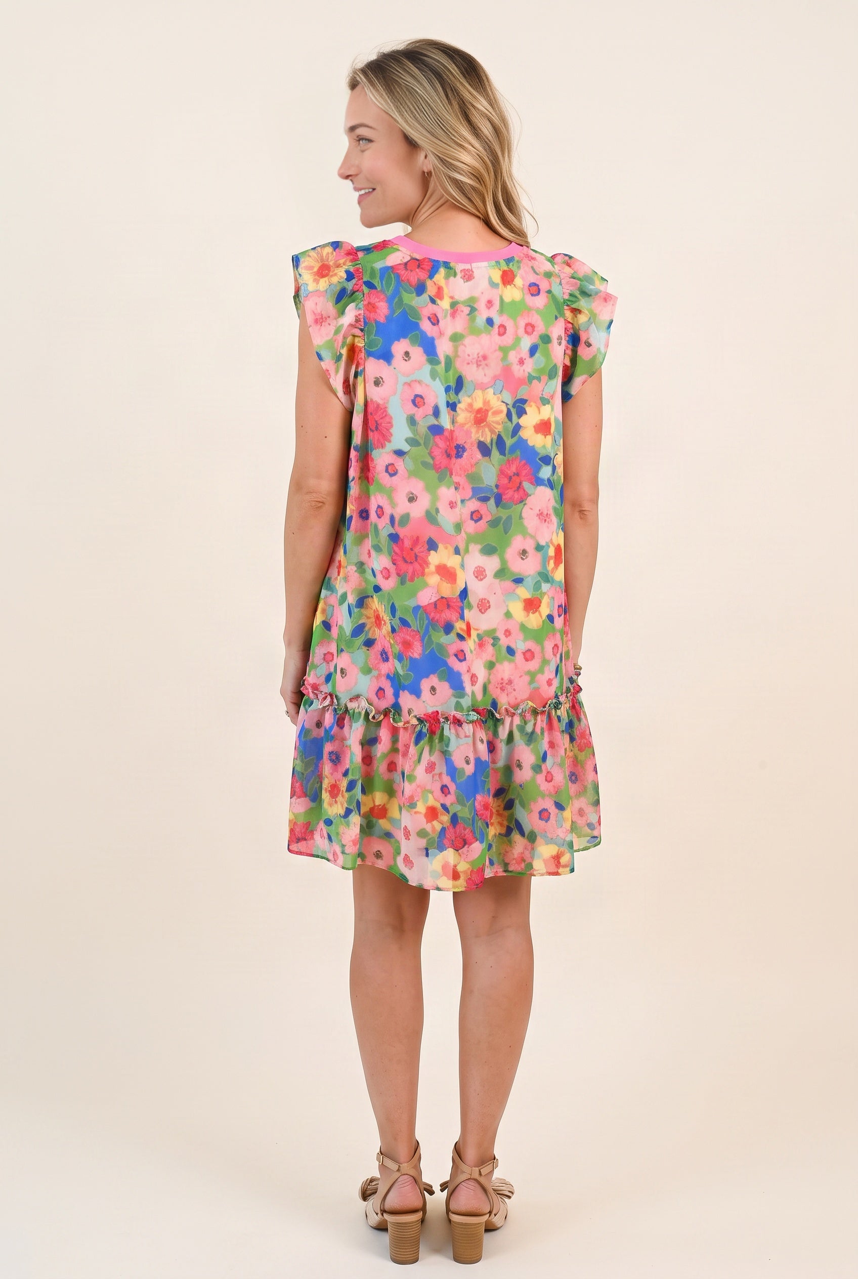 Back view of the Keep Blooming floral mini dress showing the neckline, loose fit and gathered lower tier.