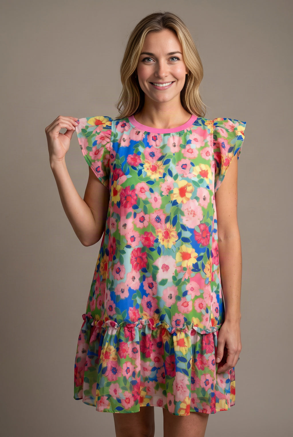 Close view of the Keep Blooming dress showing the flutter sleeve, pink neckline and lightweight floral shell.
