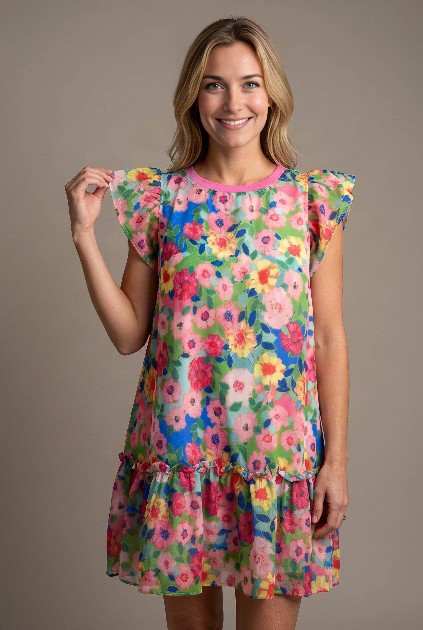 Close view of the Keep Blooming dress showing the flutter sleeve, pink neckline and lightweight floral shell.