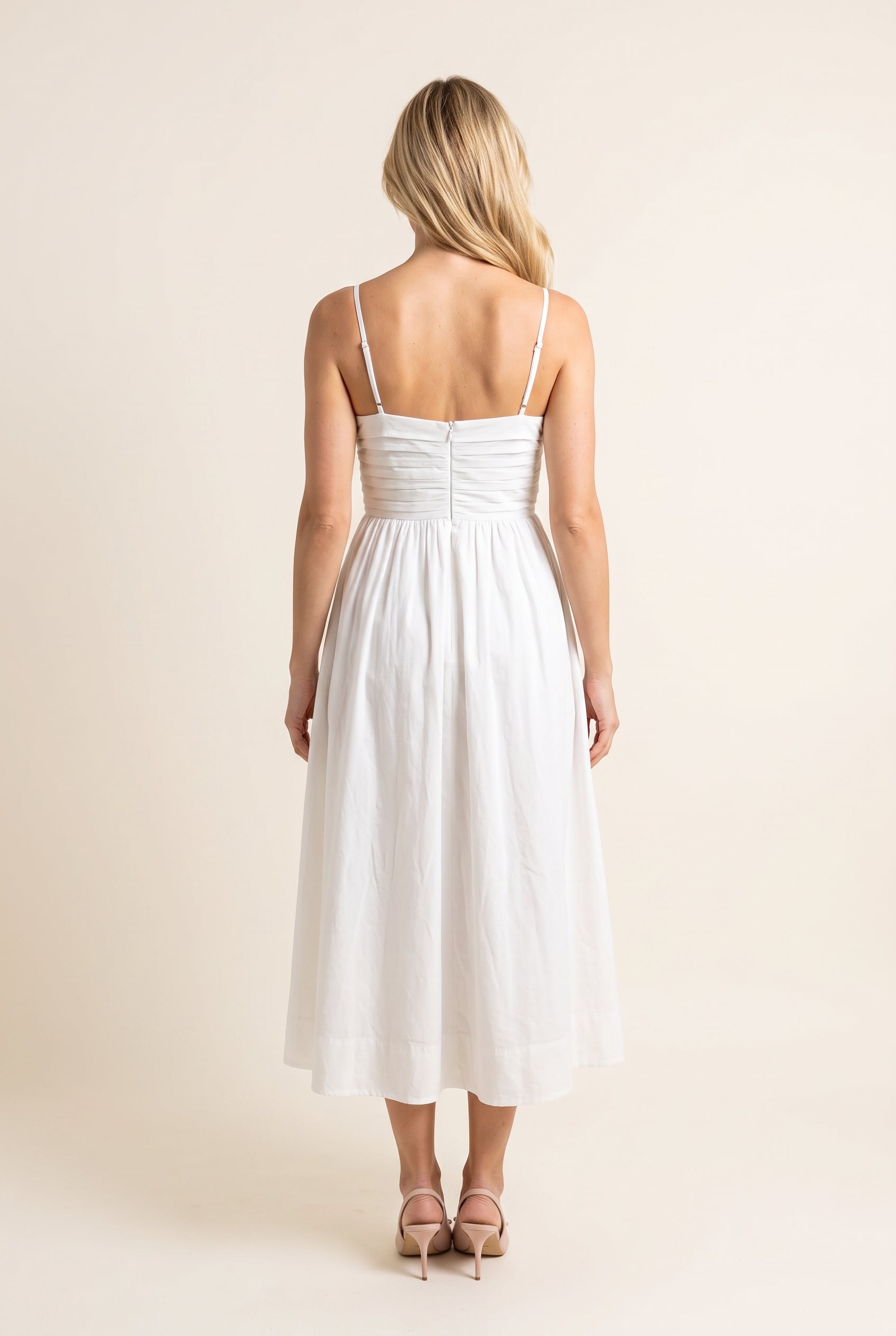 Back view of the Love Actually White Pleated Midi Dress showing its low neckline and adjustable straps.