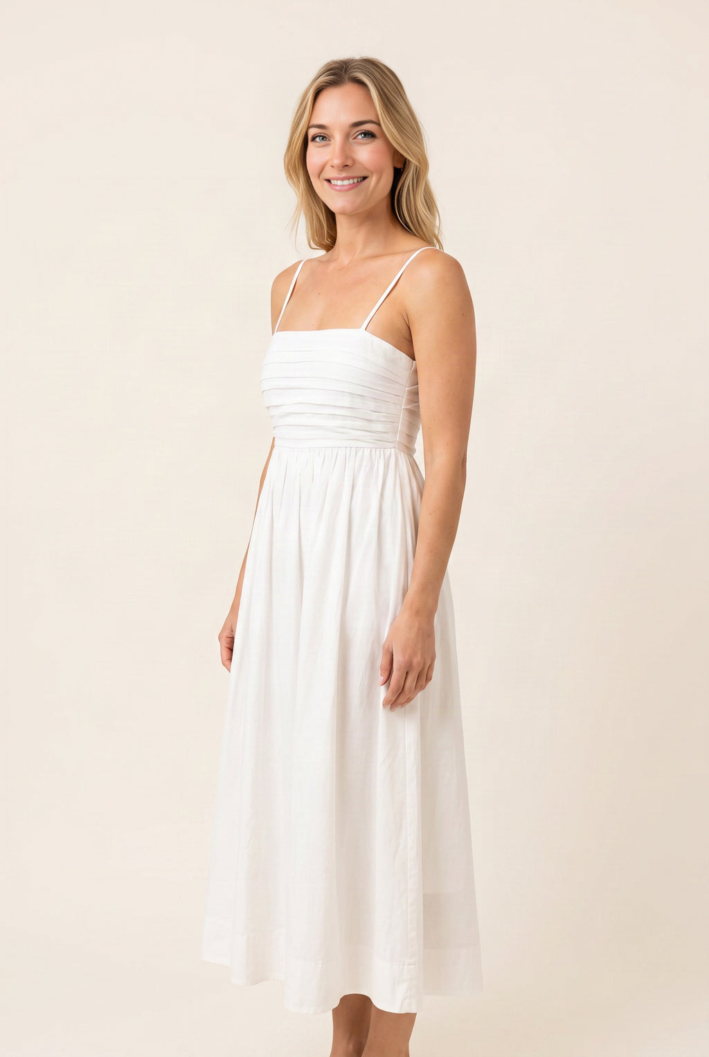 Angled side view of the Love Actually White Pleated Midi Dress showing waist placement and skirt volume.