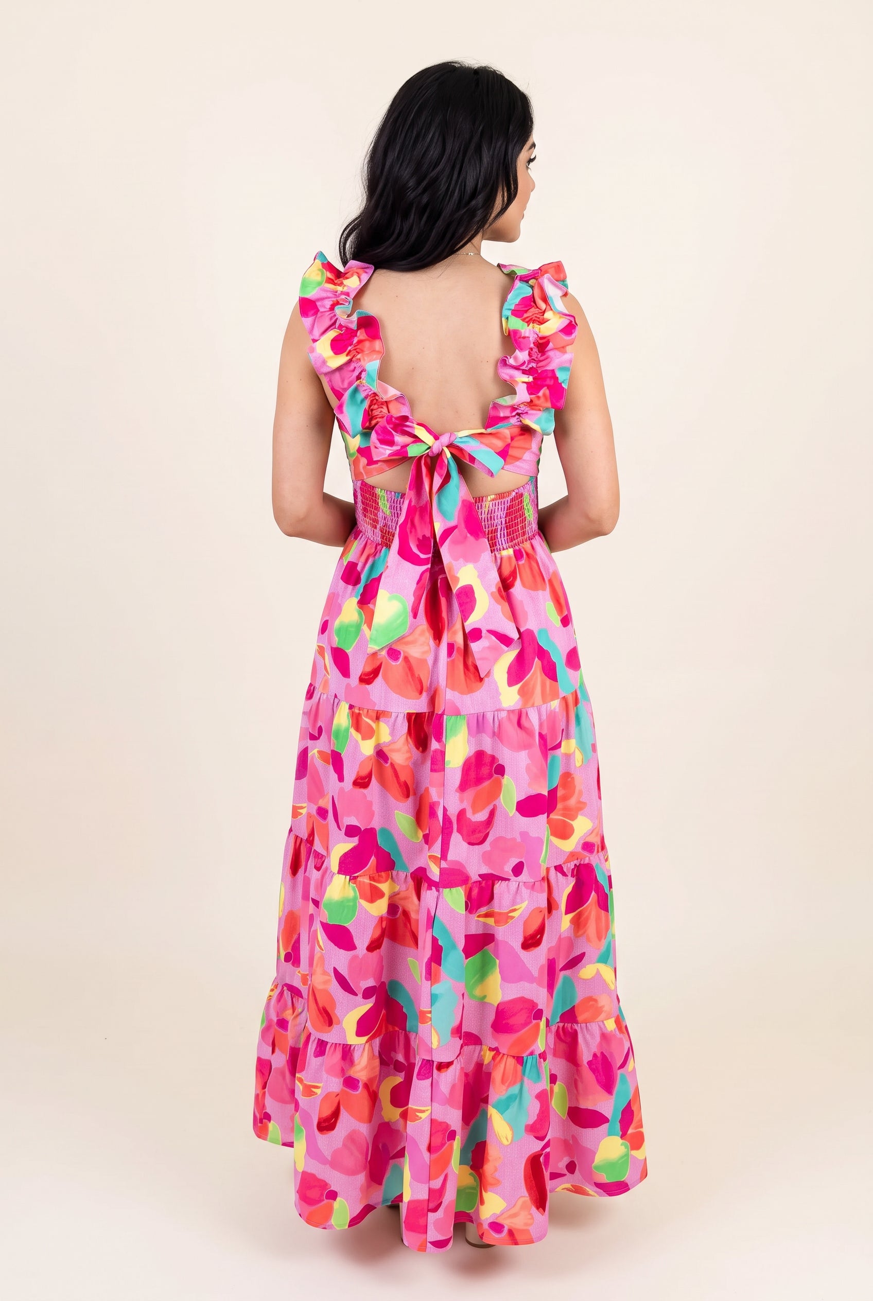 Back view of the Blooming Affair maxi dress showing the open back, tie bow and shirred waist.