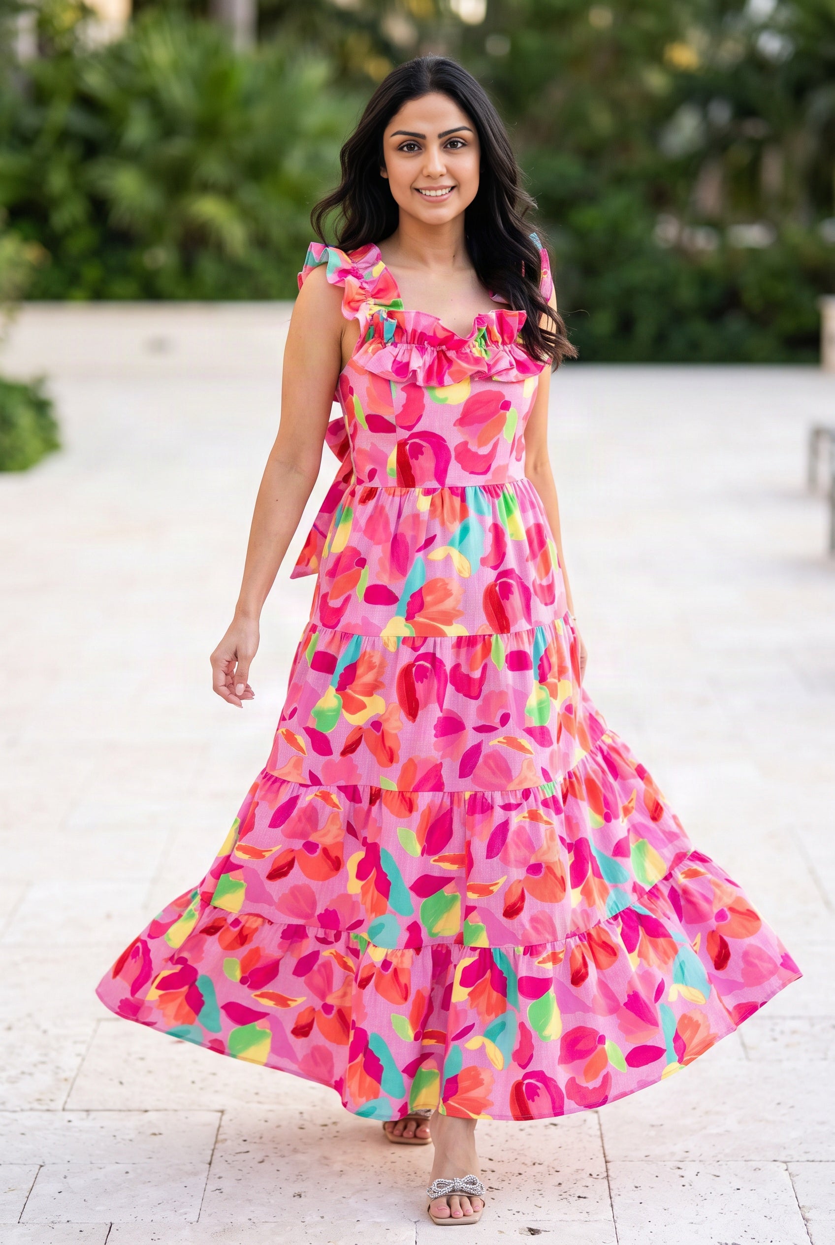 Blooming Affair floral maxi dress worn while walking on a sunny resort patio, showing the tiered skirt in motion.
