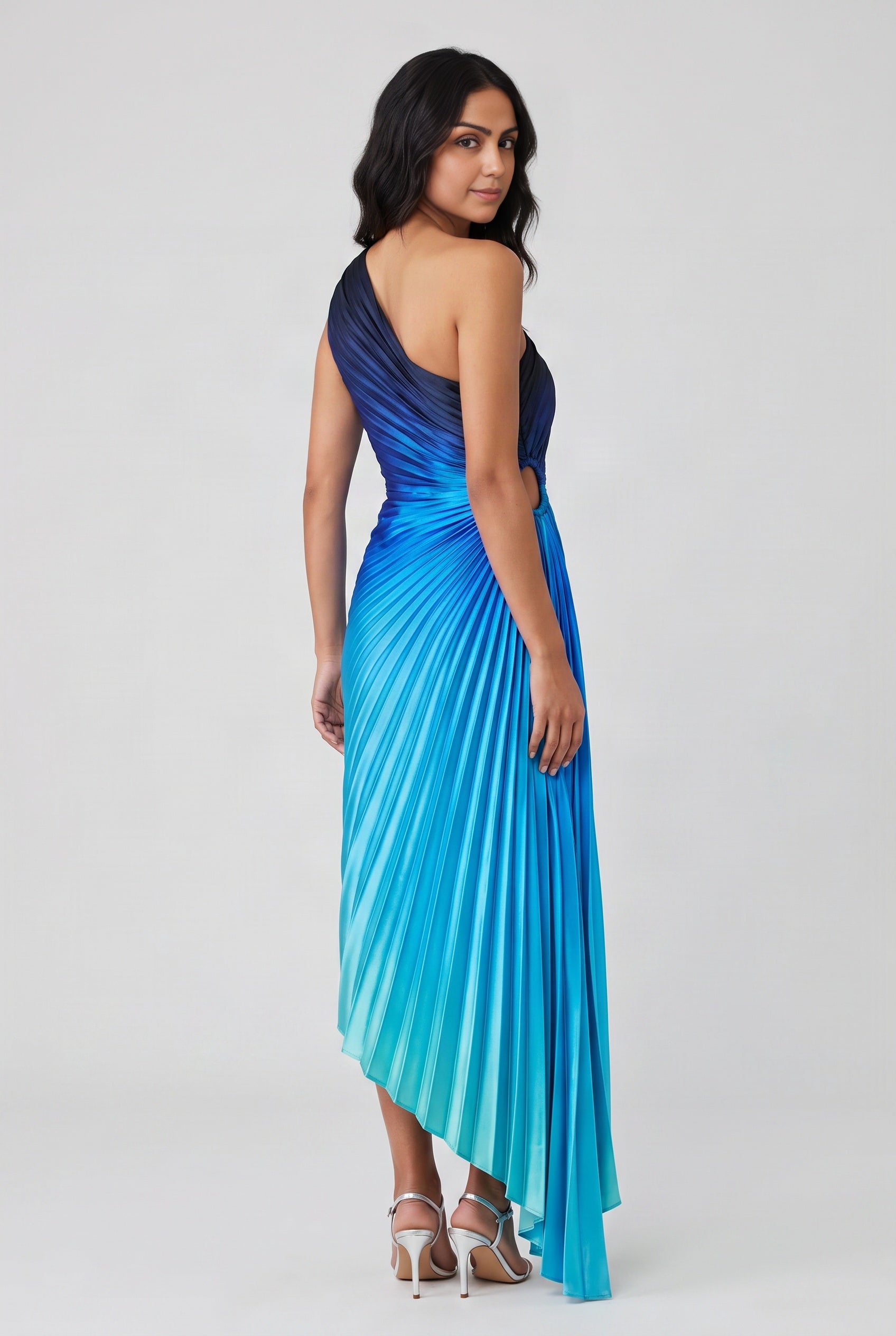 Back view of the blue ombre pleated maxi dress showing its open back and long pleated hem.