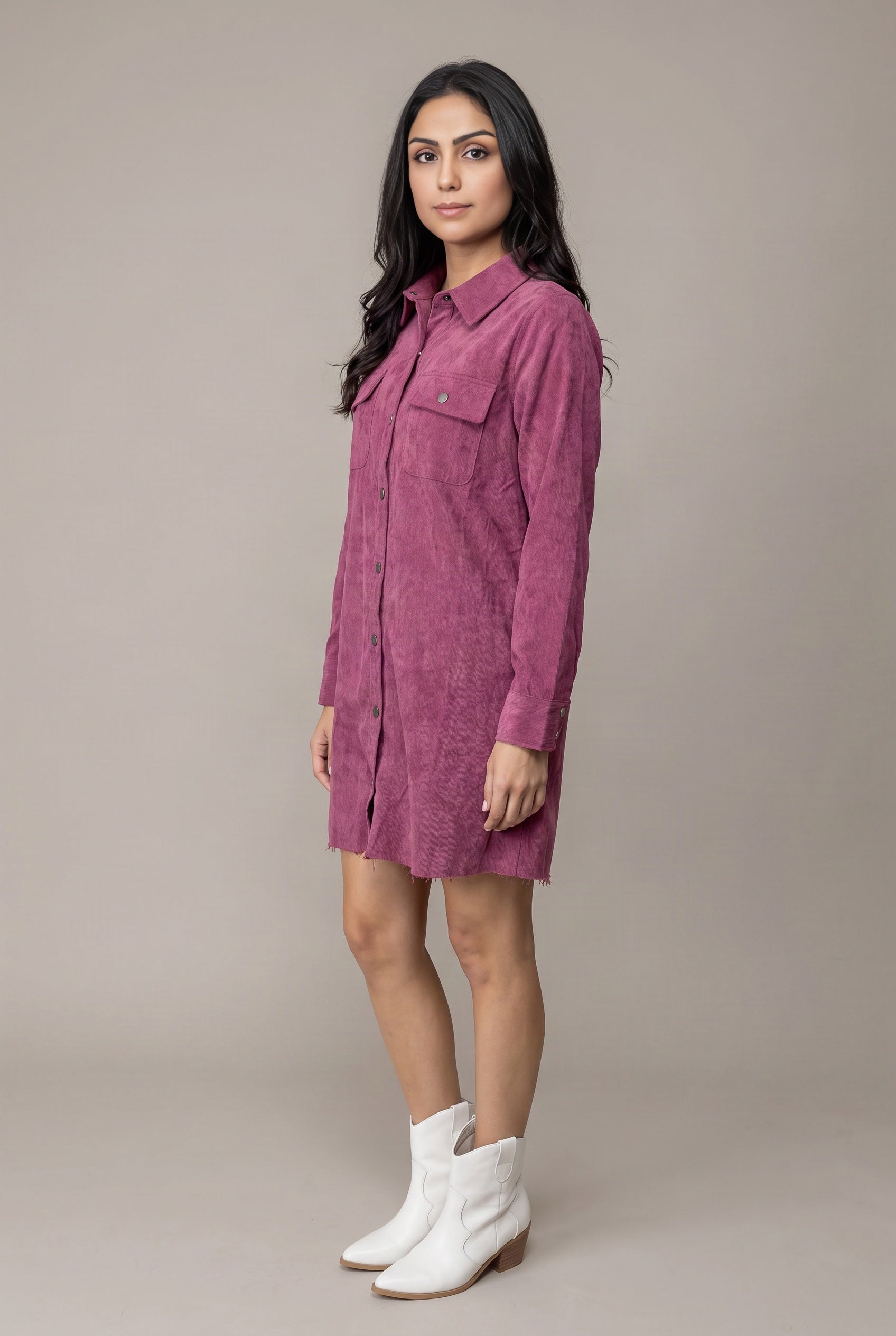 Angled side view of the Small mauve corduroy shirt dress showing its loose body and short hem.