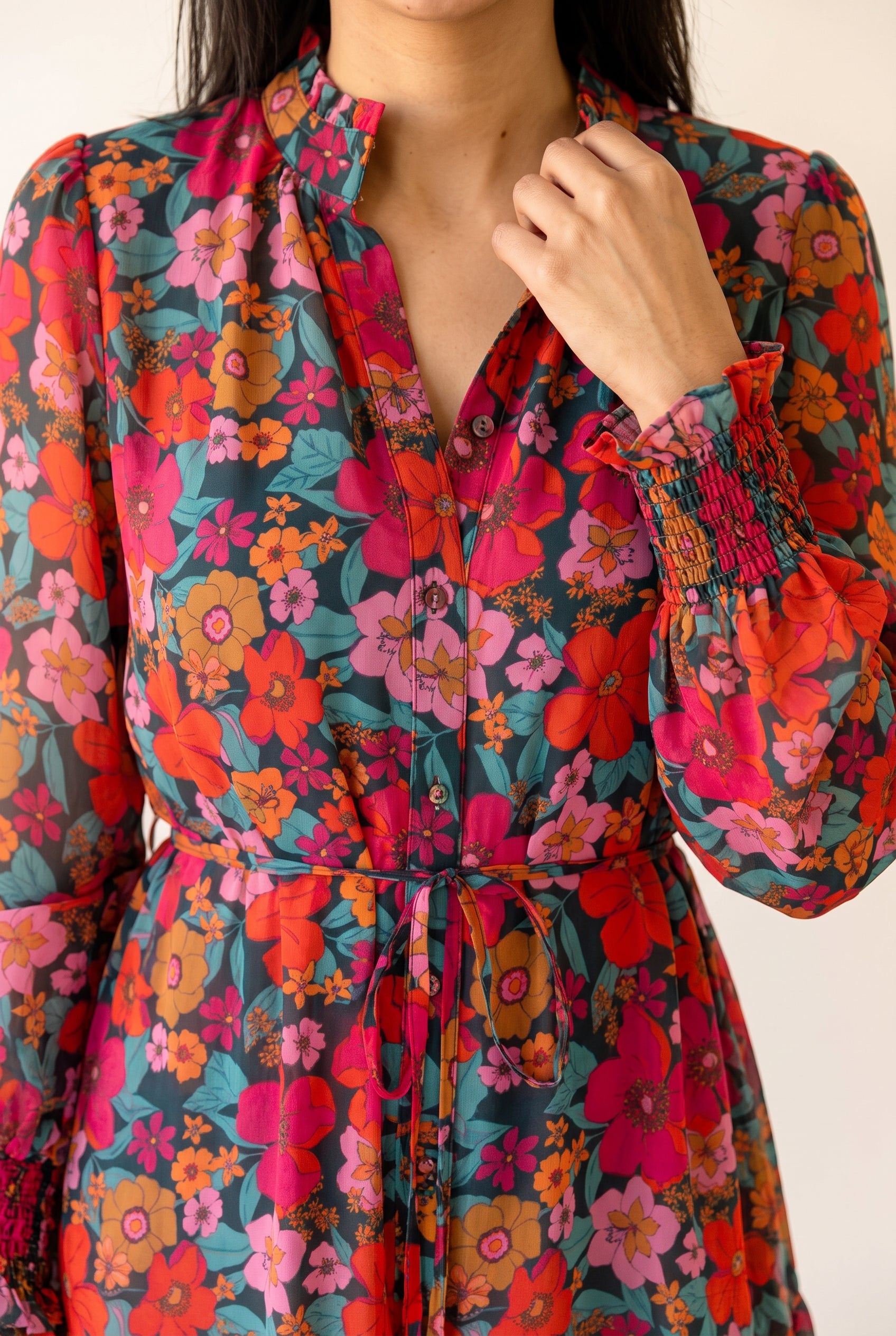 Close detail of the Only If You Knew Floral Dress showing its ruffled neckline, buttons and smocked cuff