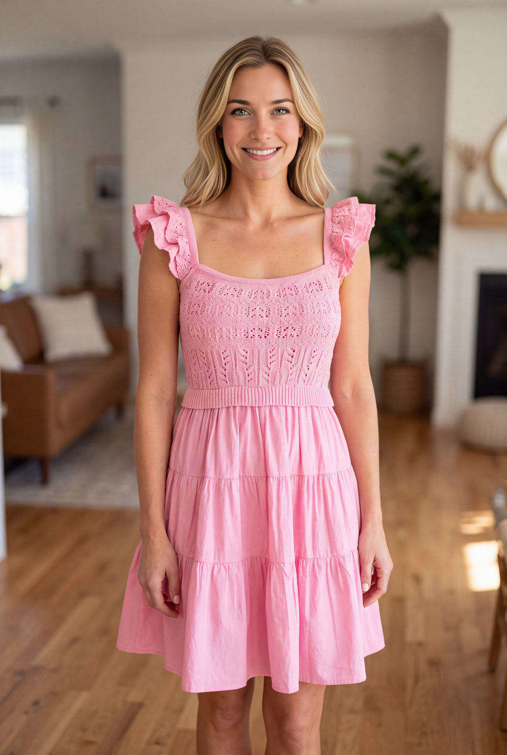 Close view of the pink dress showing the openwork bodice, ribbed waist and layered shoulder ruffles.