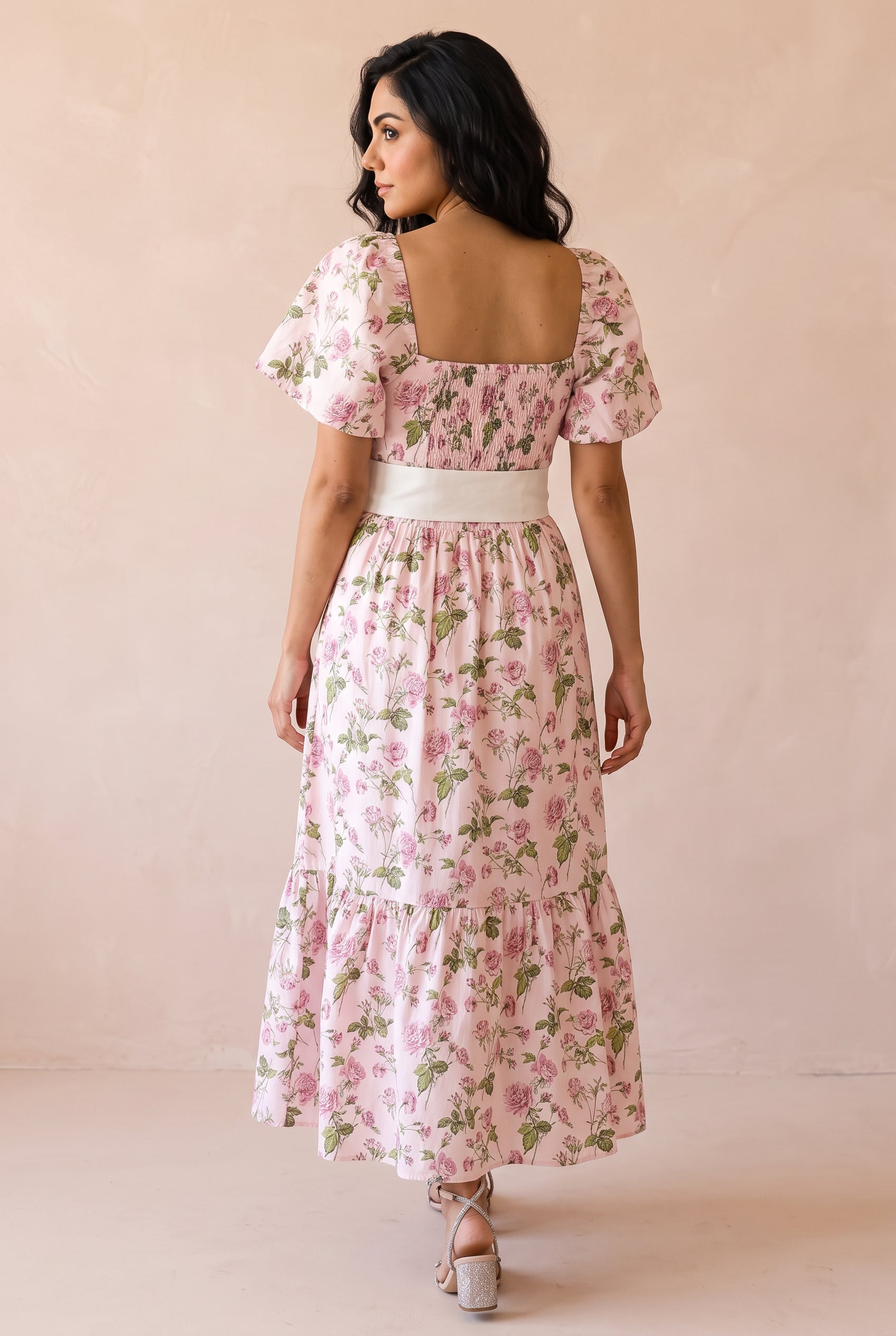 Back view of the pink floral maxi dress showing the square neckline, shirred bodice, and full tiered skirt.