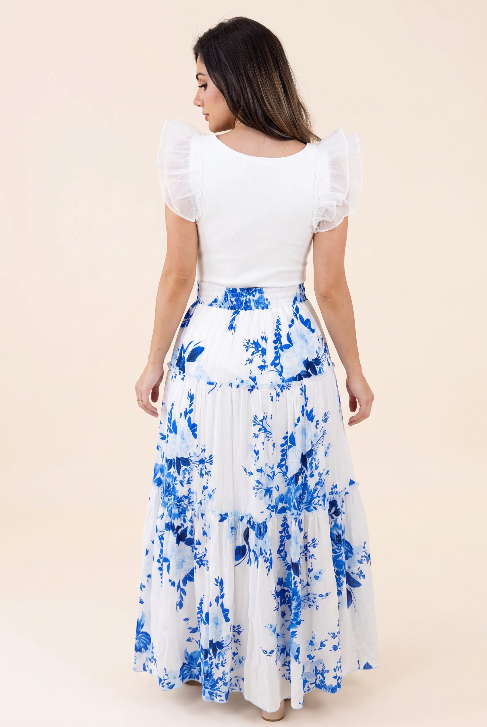 Back view of the blue floral tiered maxi skirt showing its natural drape and smocked waistband.