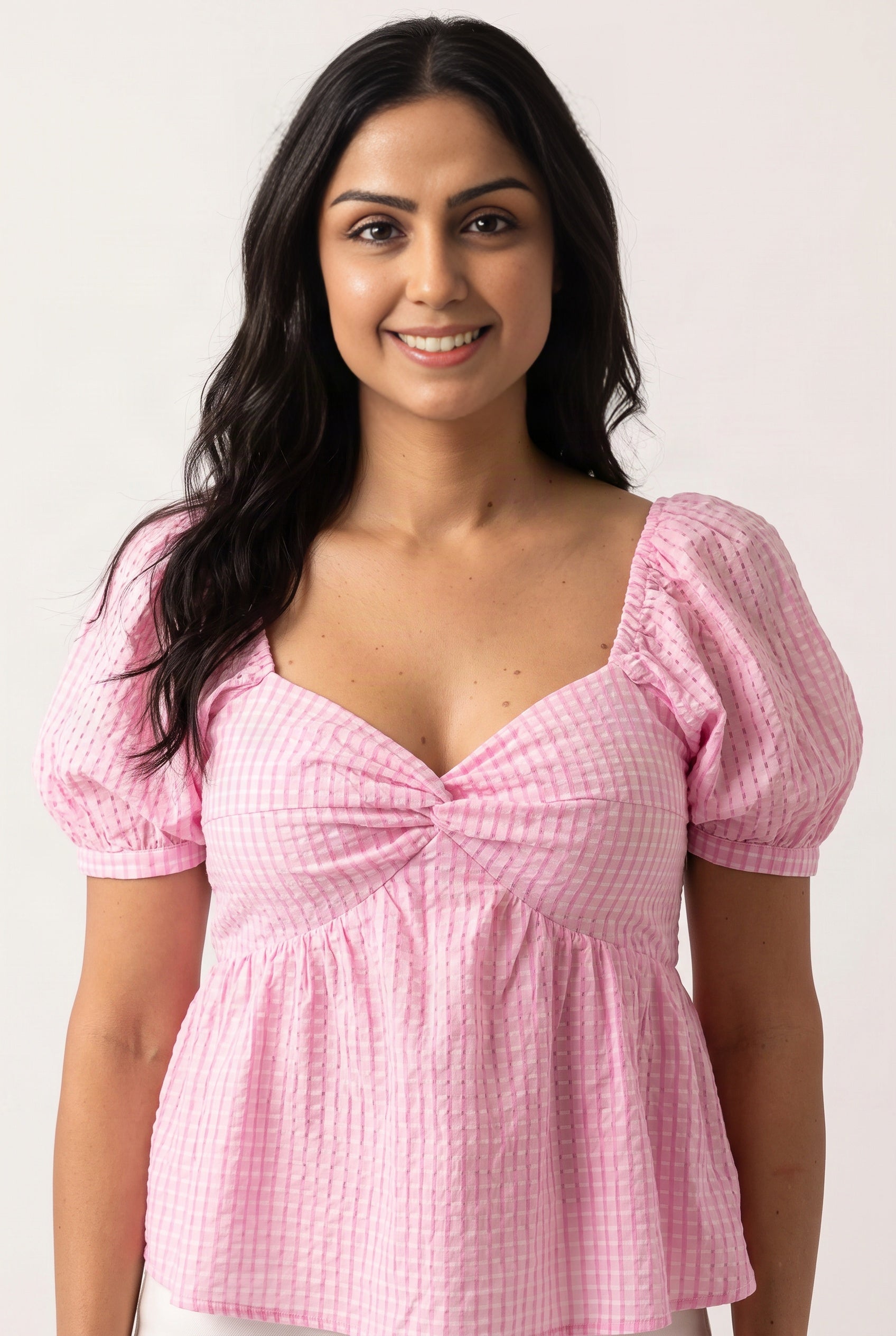 Close view of the pink gingham top showing its sweetheart dip, front twist and gathered empire bodice.