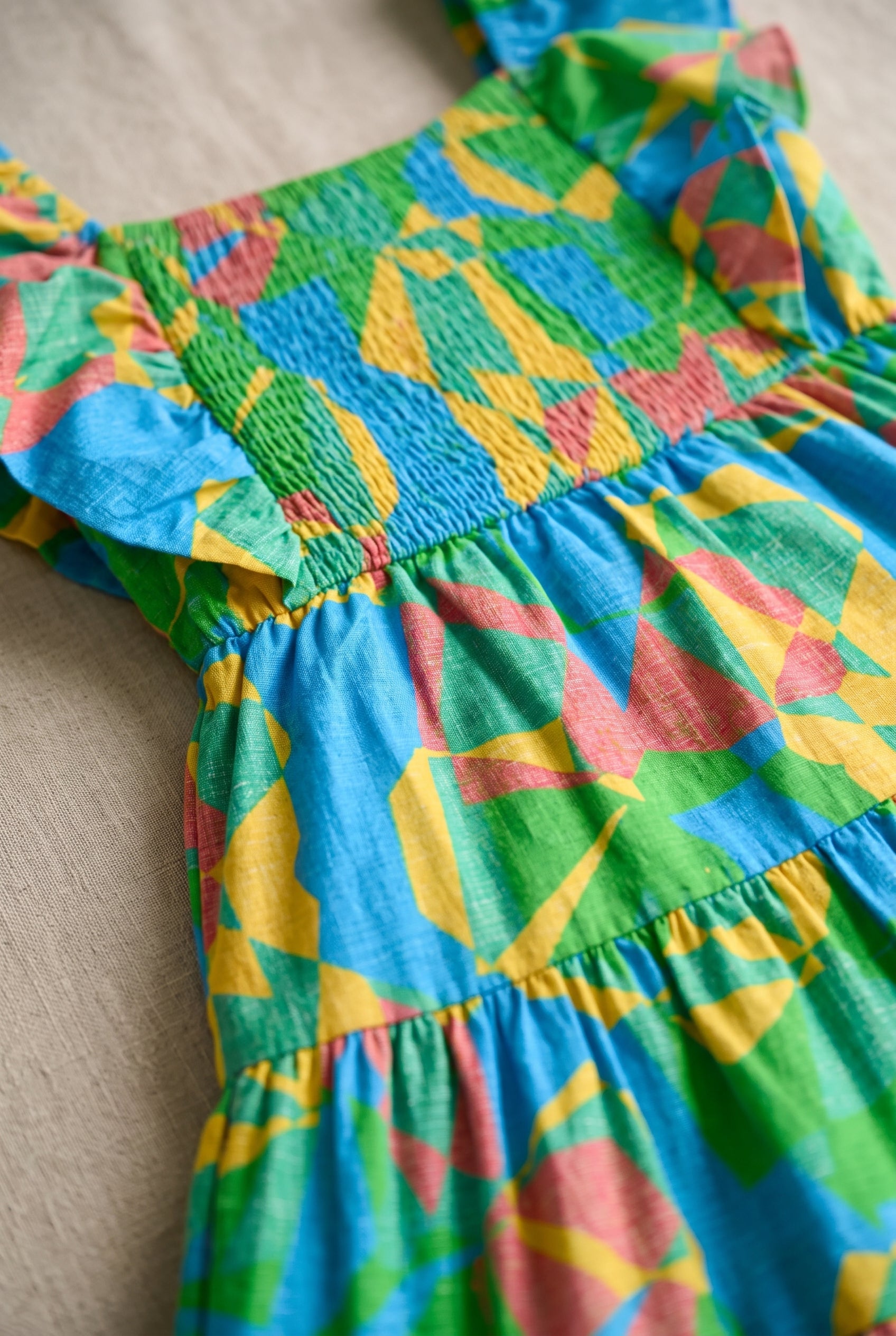 Close detail of the dress print, elastic smocking and gathered tier seam.