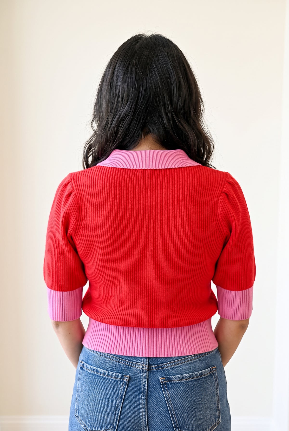 Back fit of the Small sweater showing the pink collar, red rib-knit back, and continuous waistband.