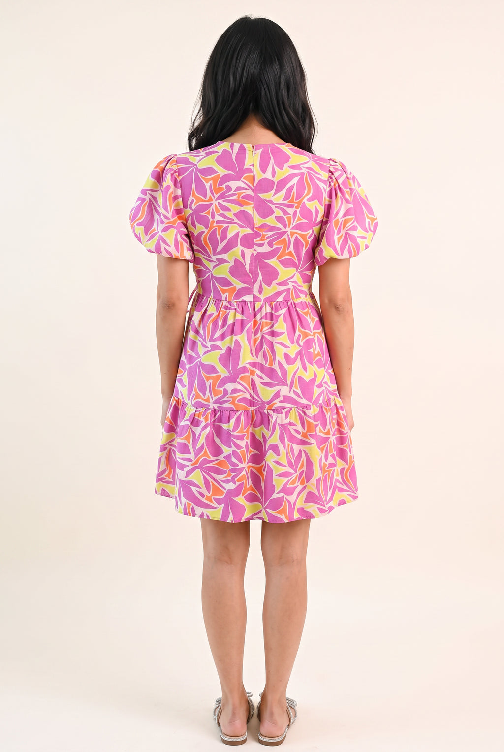Back fit of the Somewhere Sunny floral dress showing its high neckline, fitted waist and gathered tier.