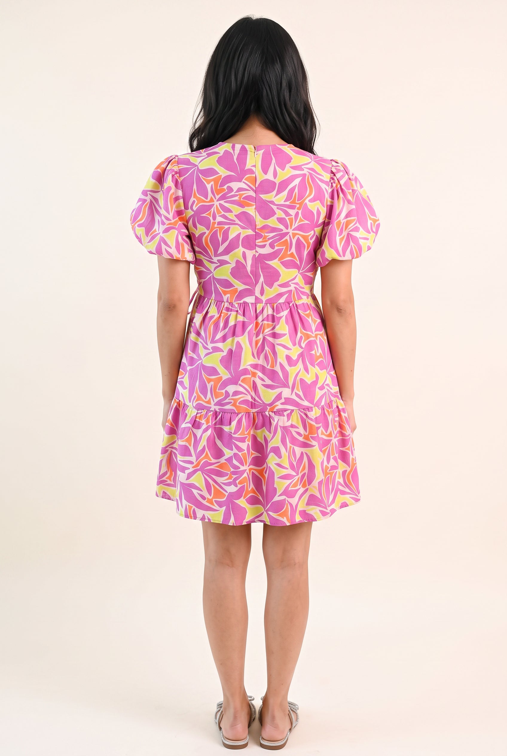 Back fit of the Somewhere Sunny floral dress showing its high neckline, fitted waist and gathered tier.