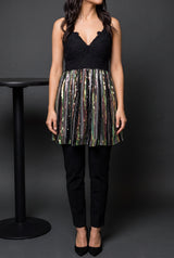 Small sequin tunic top styled with black trousers and heels for a restrained party look.