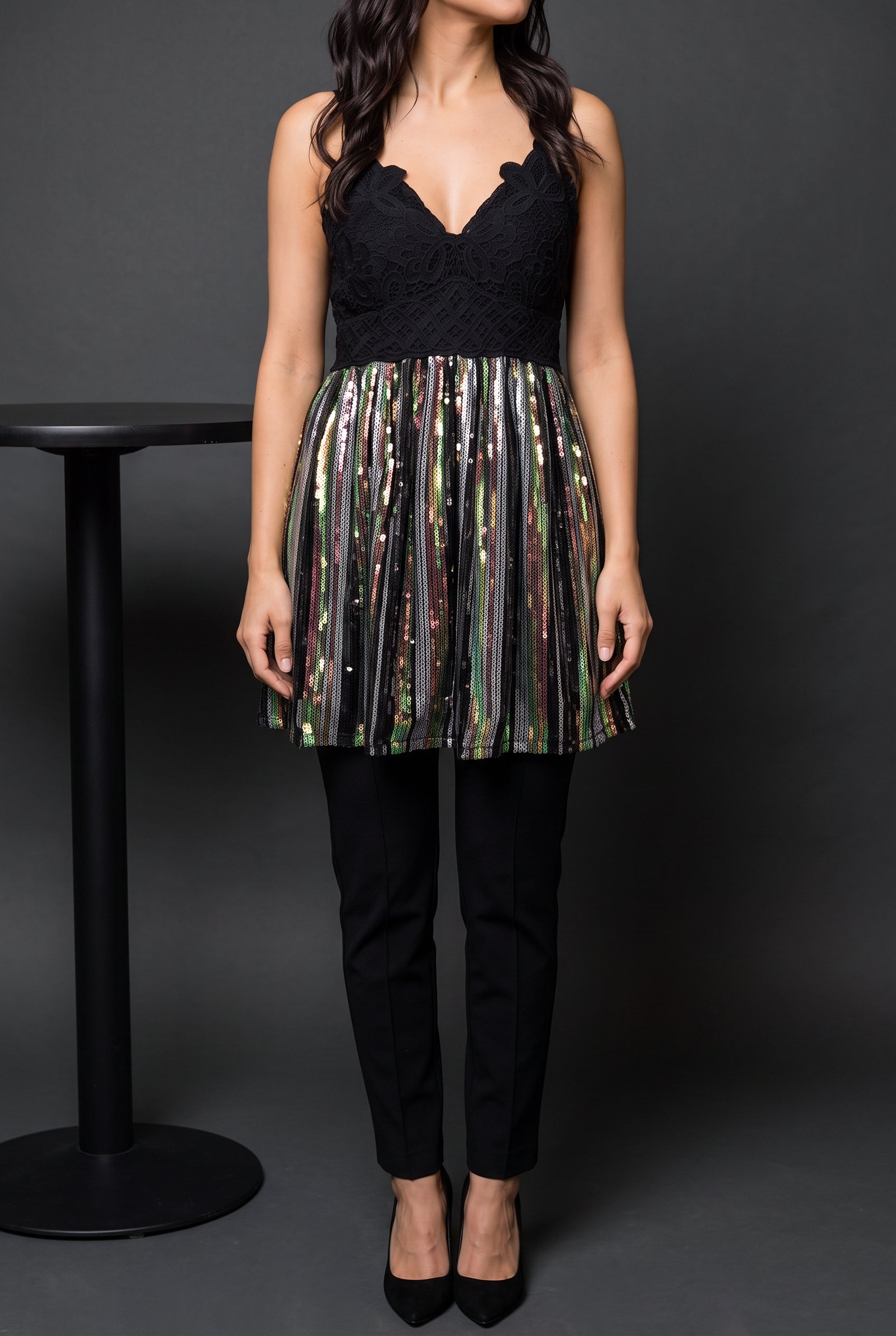 Small sequin tunic top styled with black trousers and heels for a restrained party look.