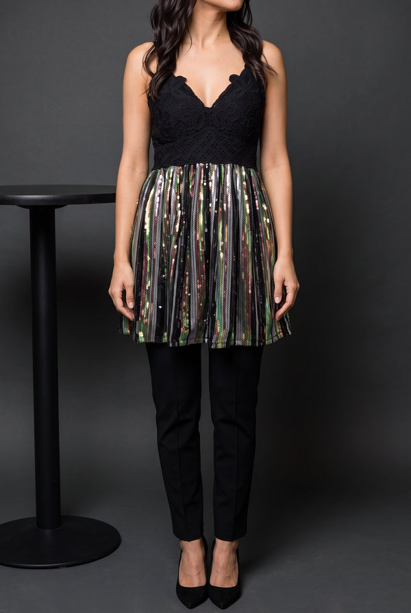 Small sequin tunic top styled with black trousers and heels for a restrained party look.