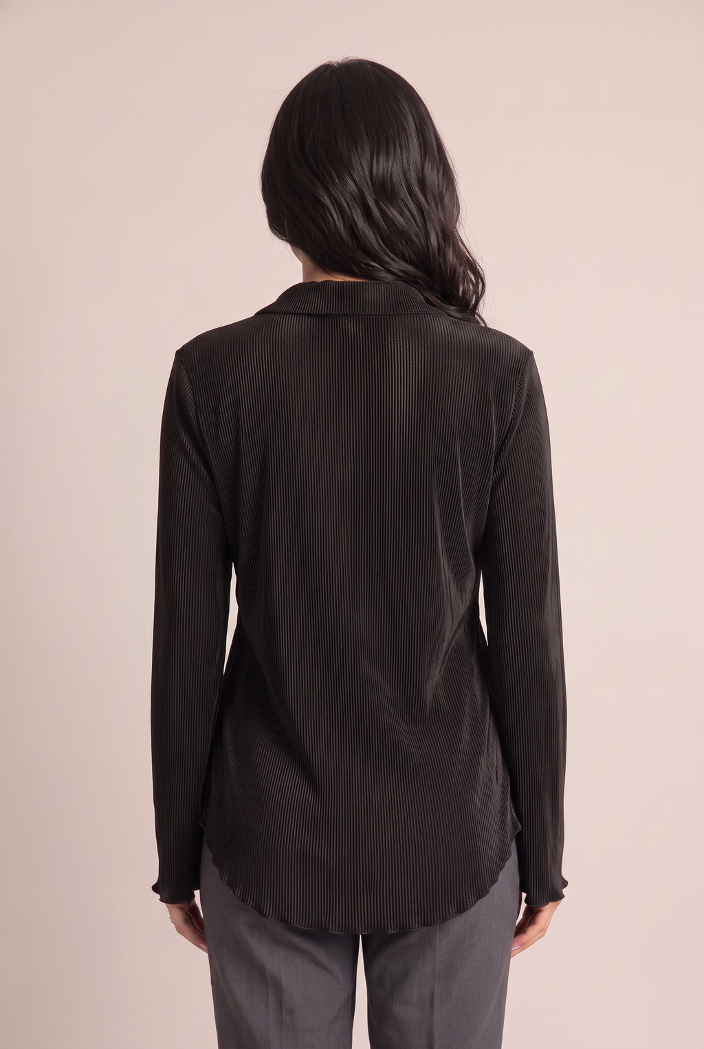 Back fit of the Small Black pleated top showing its clean back and longer rounded shirttail hem.