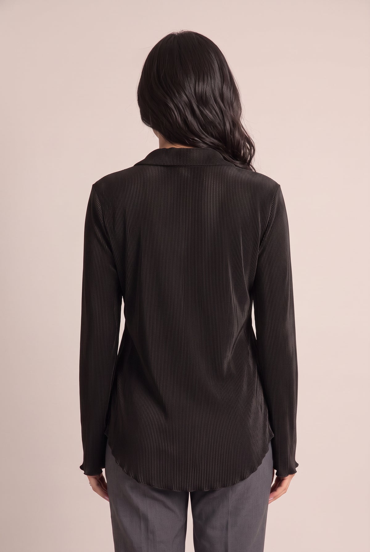 Back fit of the Small Black pleated top showing its clean back and longer rounded shirttail hem.