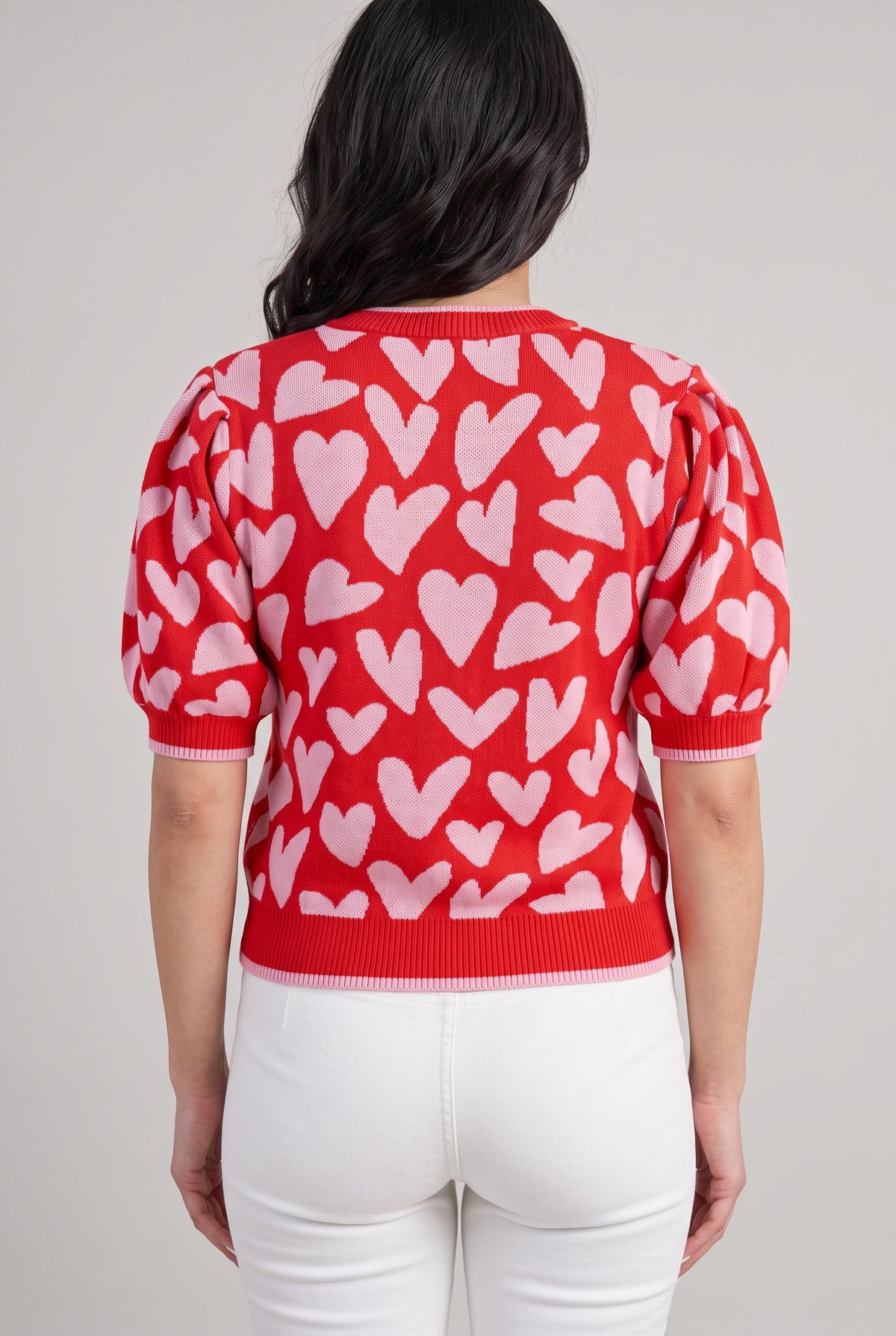 Back fit of the Love Knows All heart sweater in Small, showing the rear motif, puff sleeves, and ribbed hem.