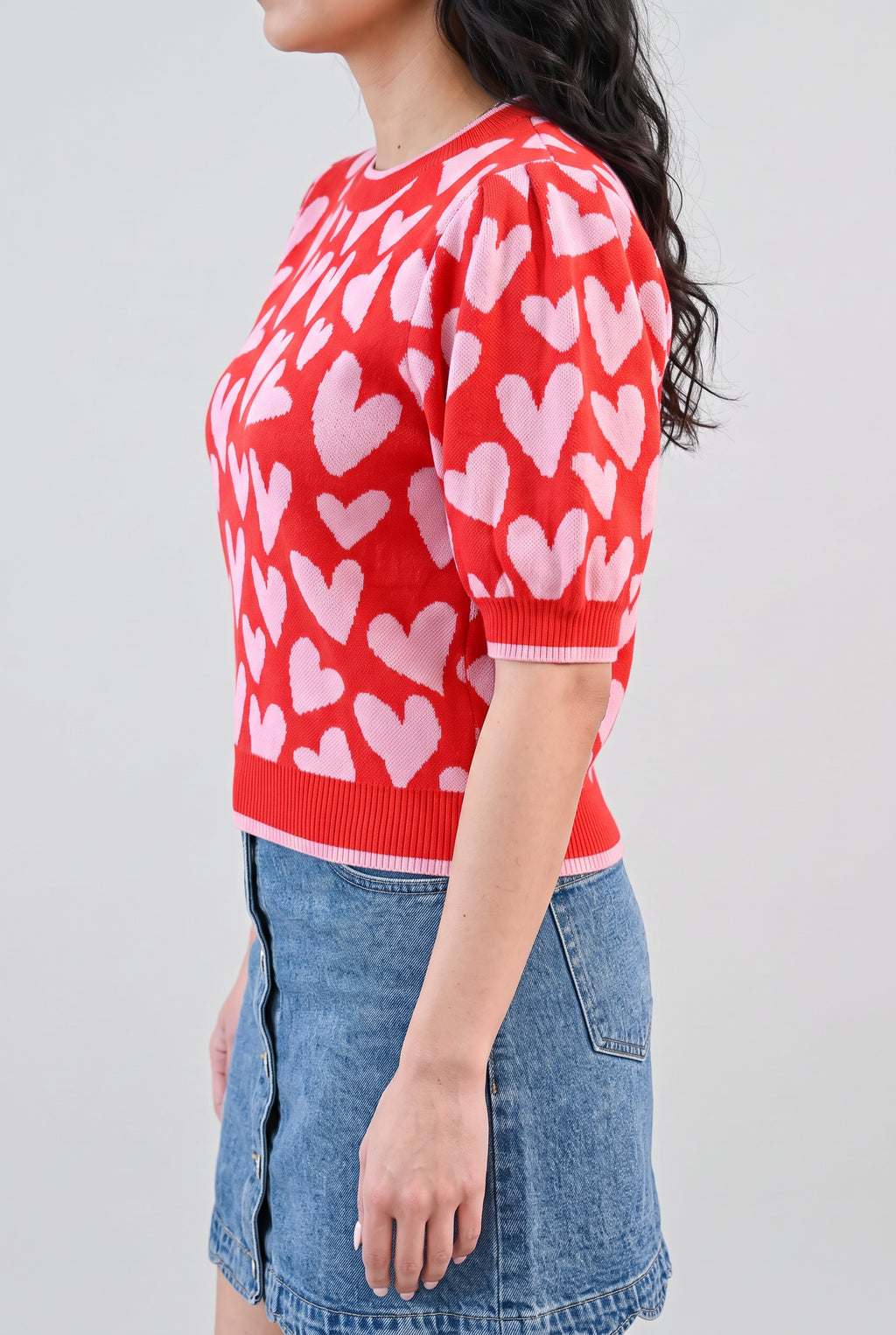 Angled side fit of the heart sweater in Small, showing puff-sleeve depth, cuff fit, and body length.