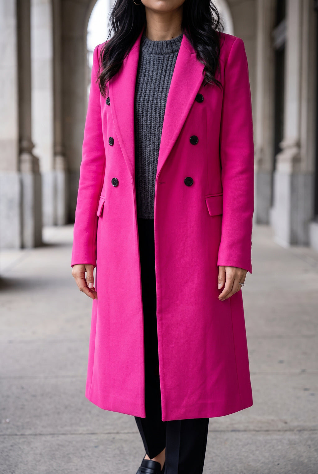 Small hot pink tailored coat over a chunky knit, showing shoulder, sleeve and layering room.