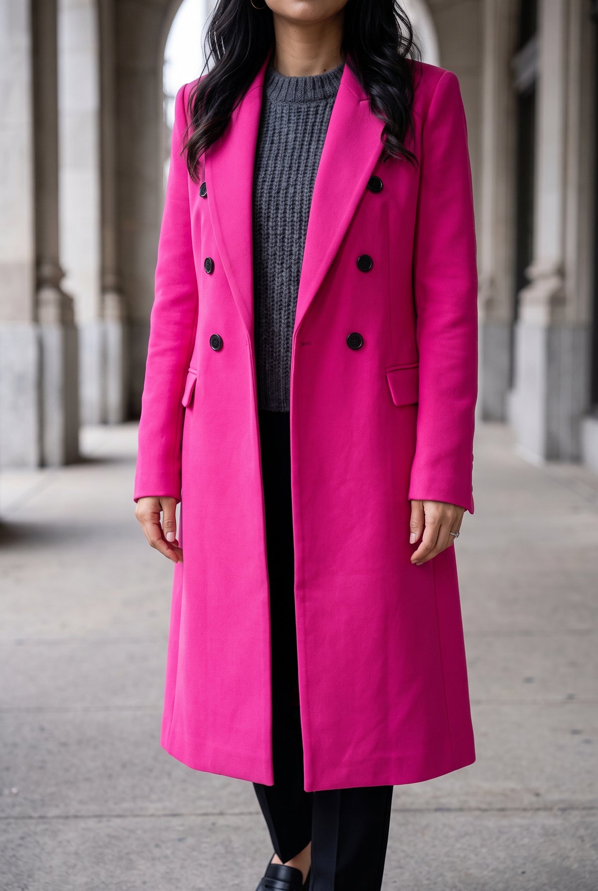 Small hot pink tailored coat over a chunky knit, showing shoulder, sleeve and layering room.