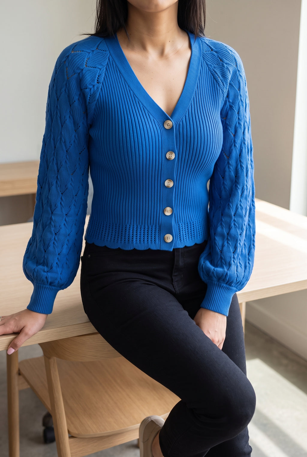 Tell Me About It Sweater Top worn seated, showing how the fitted body and sleeves settle at a desk.