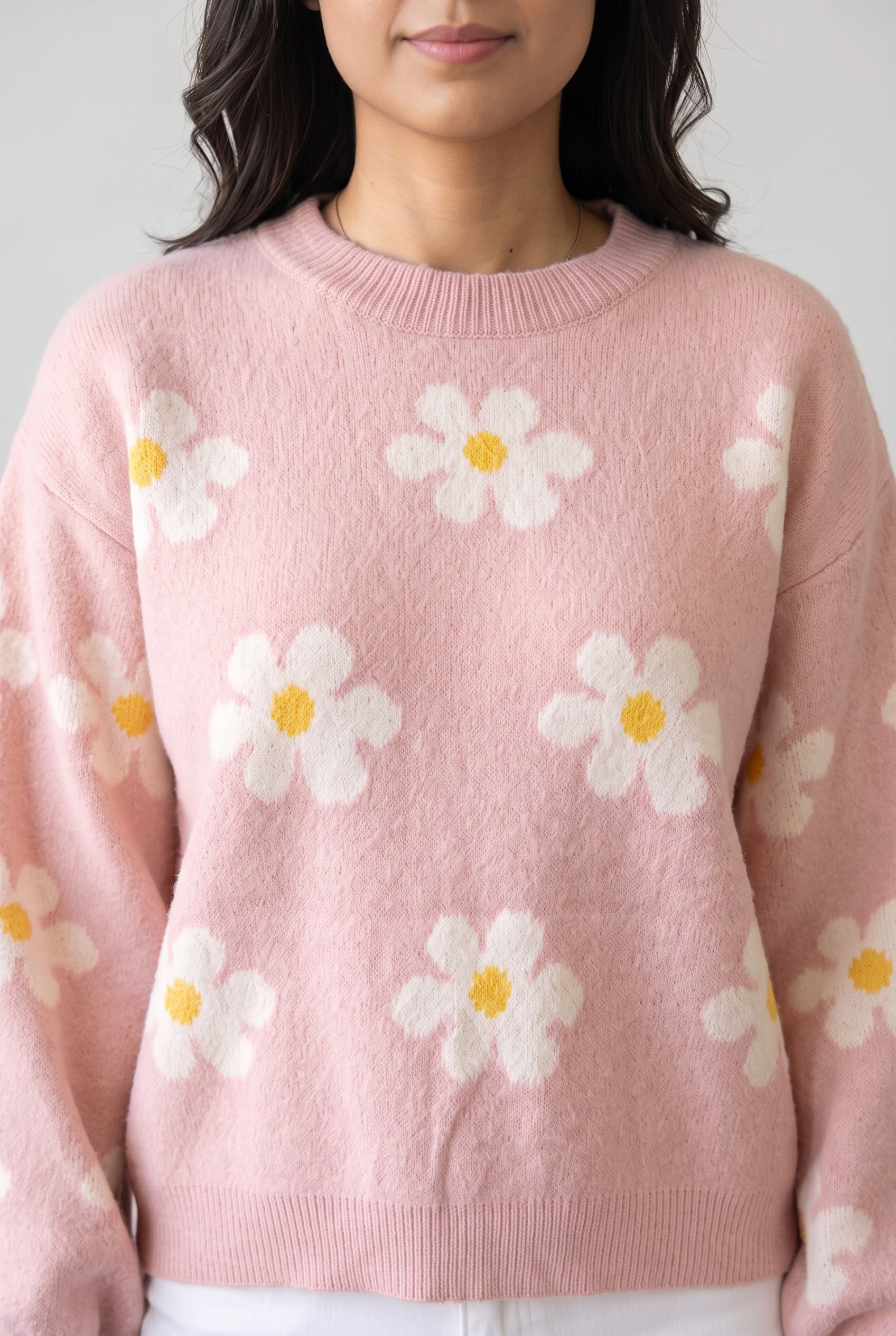 Close view of the Let's Just Stay Floral Sweater showing its ribbed crew neckline and upper daisy knit.