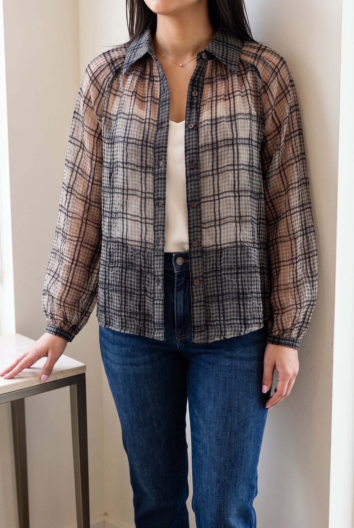 Just Looking sheer plaid blouse worn open over an ivory camisole with dark denim.